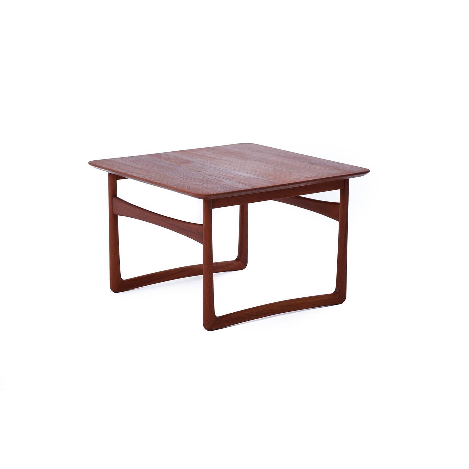 This solid teak side table makes a statement with it's sculptural sleigh base.