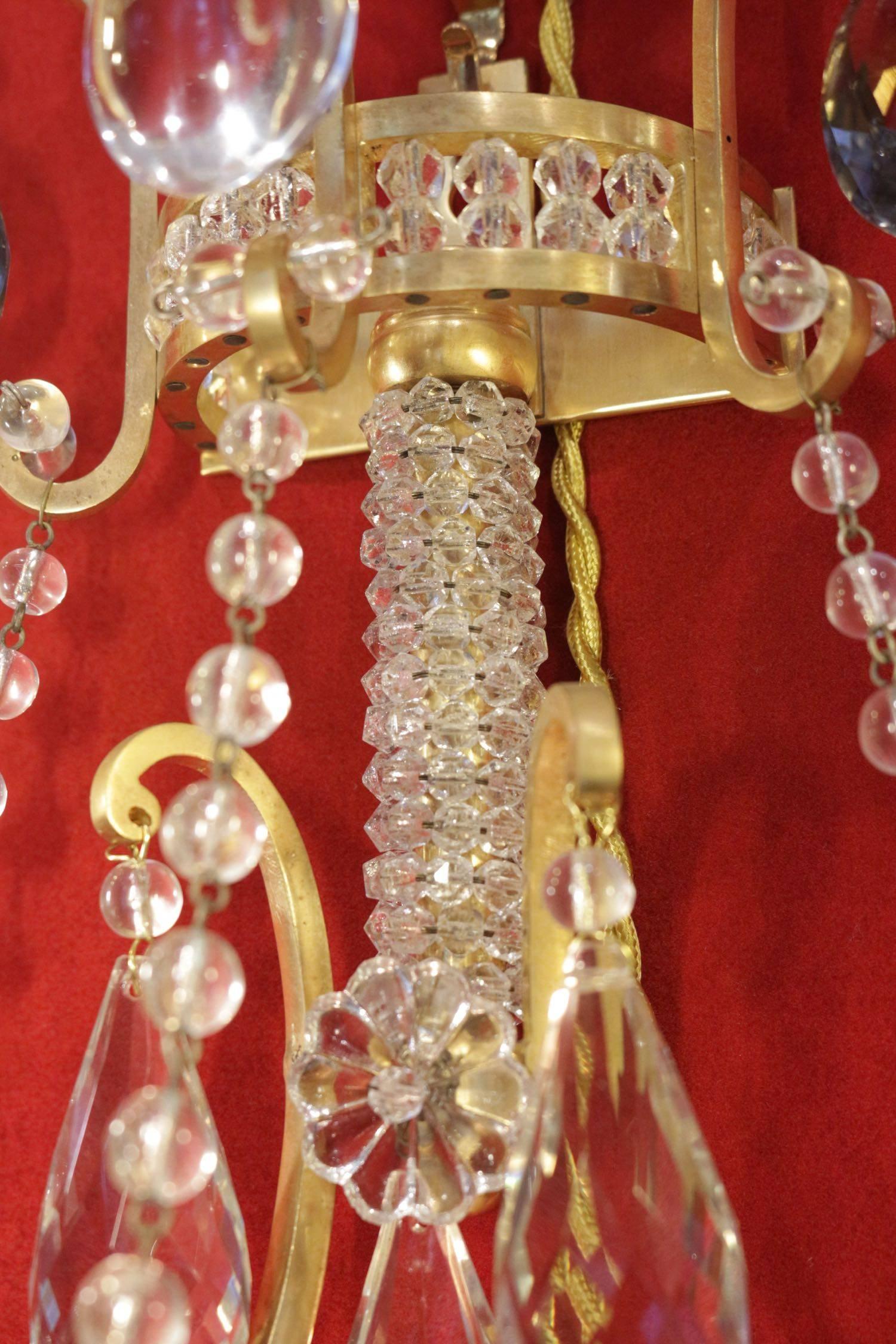 Set of four matching beautiful sconces in bronze doré and cristal drops. Three arms each. Measures: H 50cm, L 46cm, P 27cm.
 