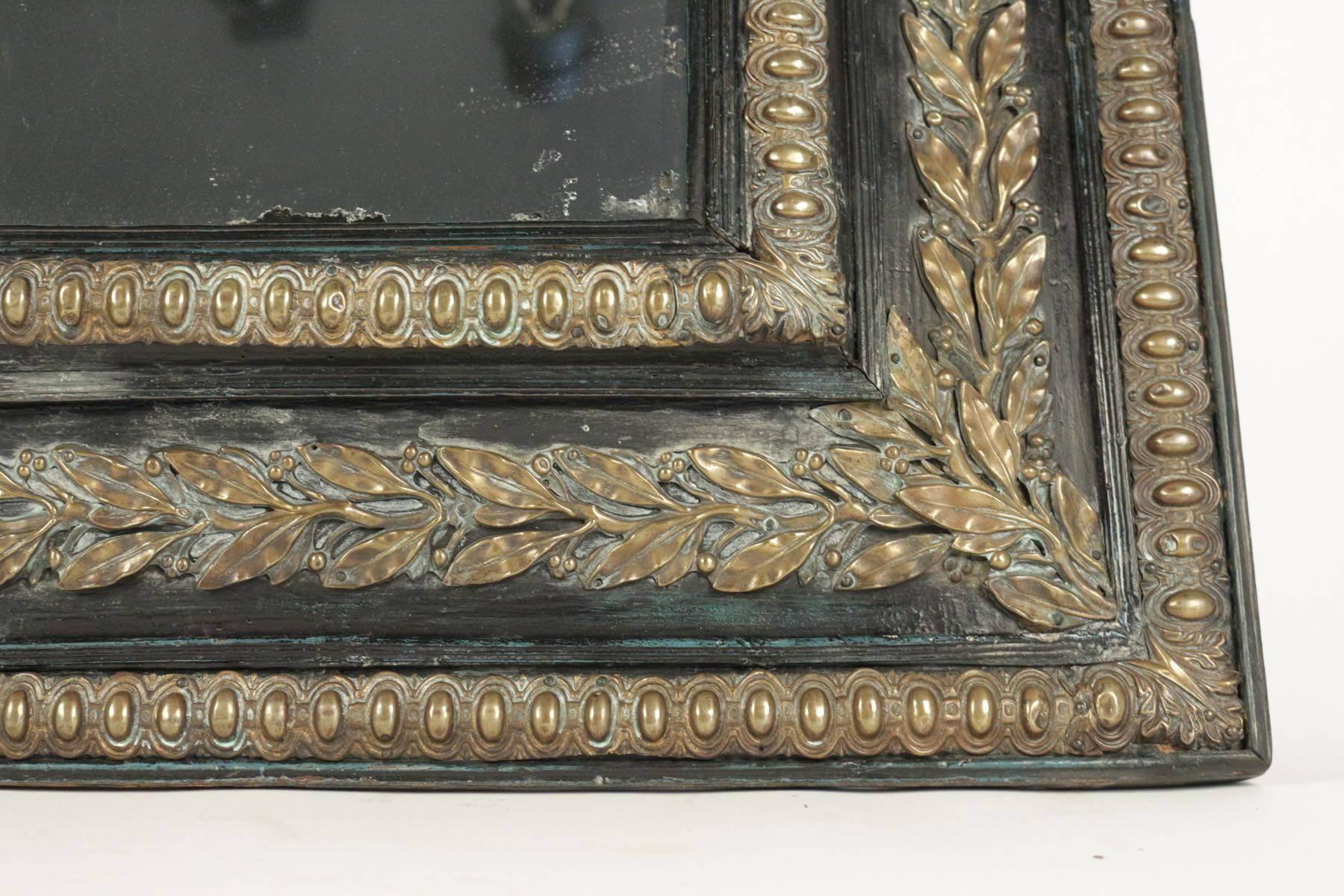 19th century mirror with its original 'mercury' glass in ebonized wood with brass motifs.
 
