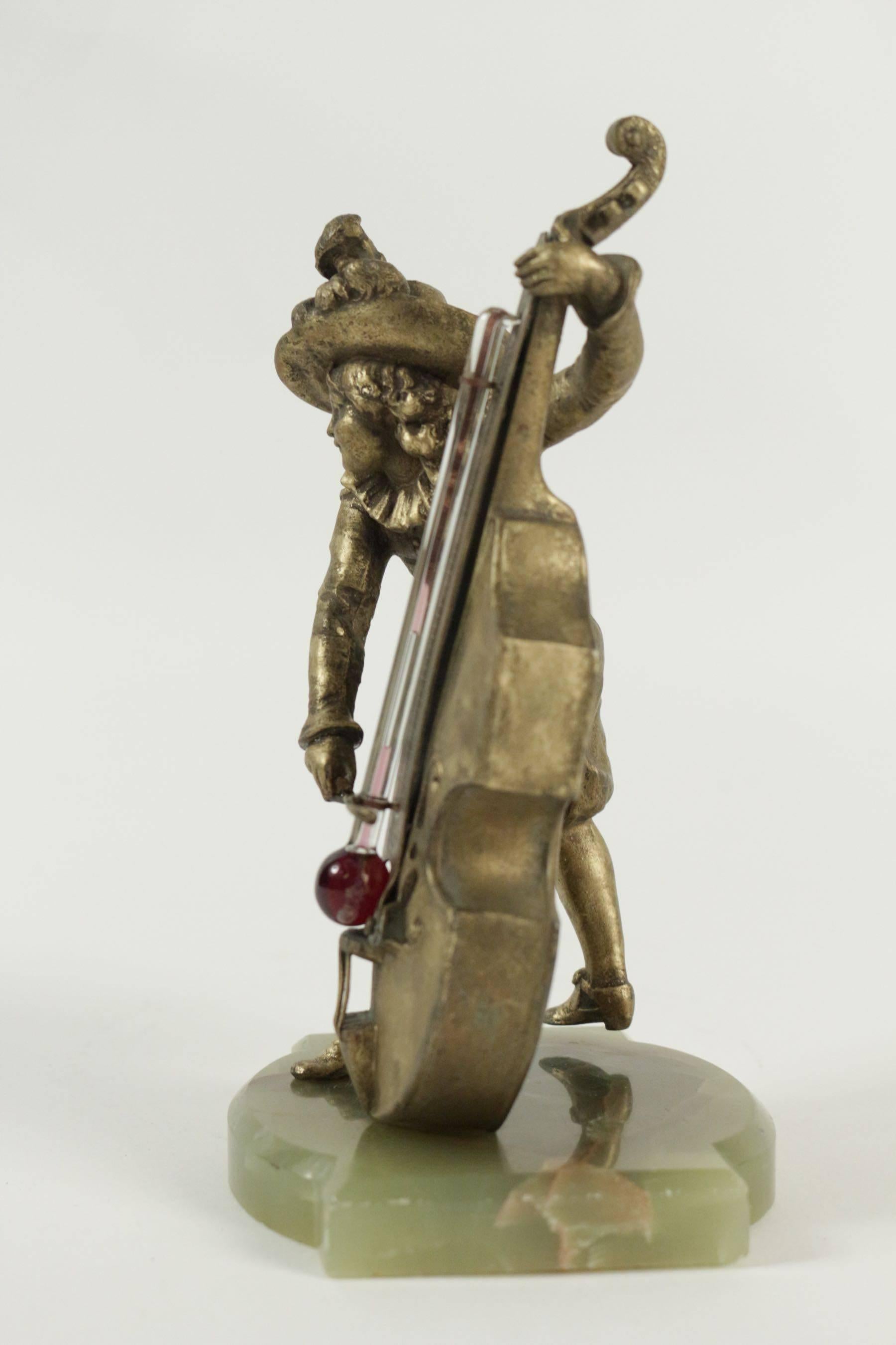 Barometer regulates and base in semi-precious stone representing a Cello player in antique. Measures: H 20cm, W 10cm.