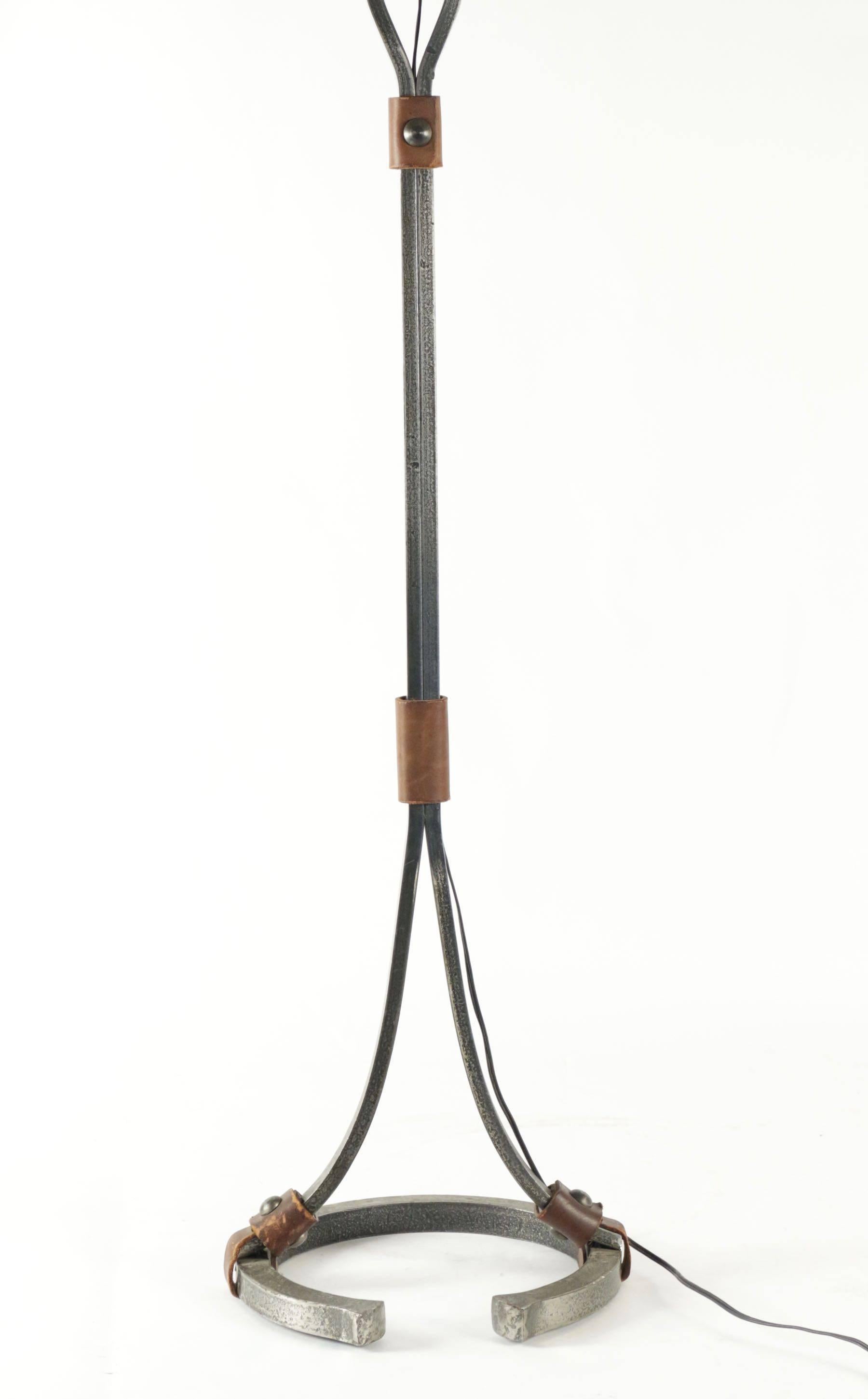 Floor lamp from the 1960s in wrought iron and leather, the bottom formed as a horse shoe.
   