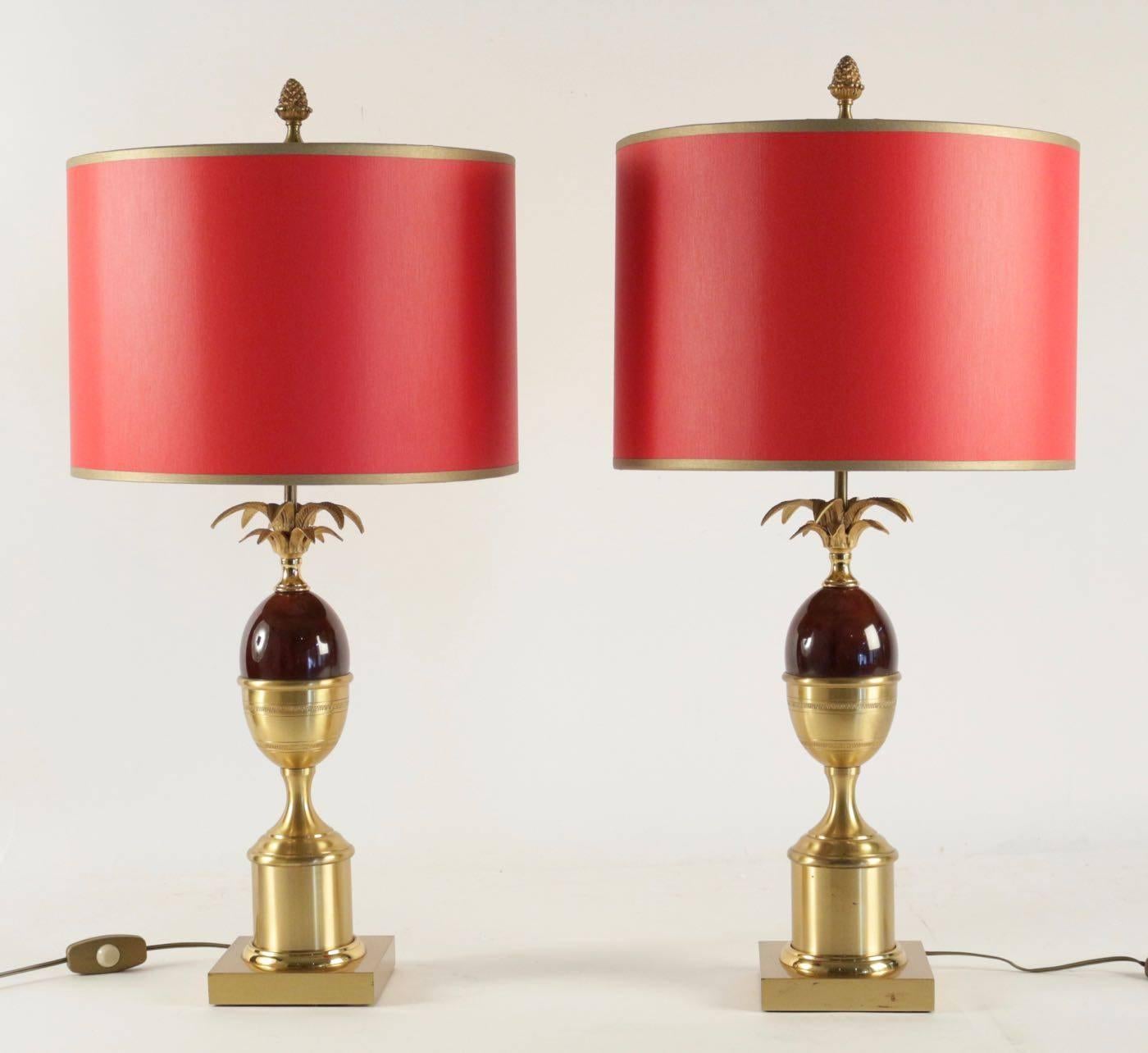 Pair of 1960s lamps in brass and resin red in the taste of Charles. Measures: H 74cm, D 36cm.
      