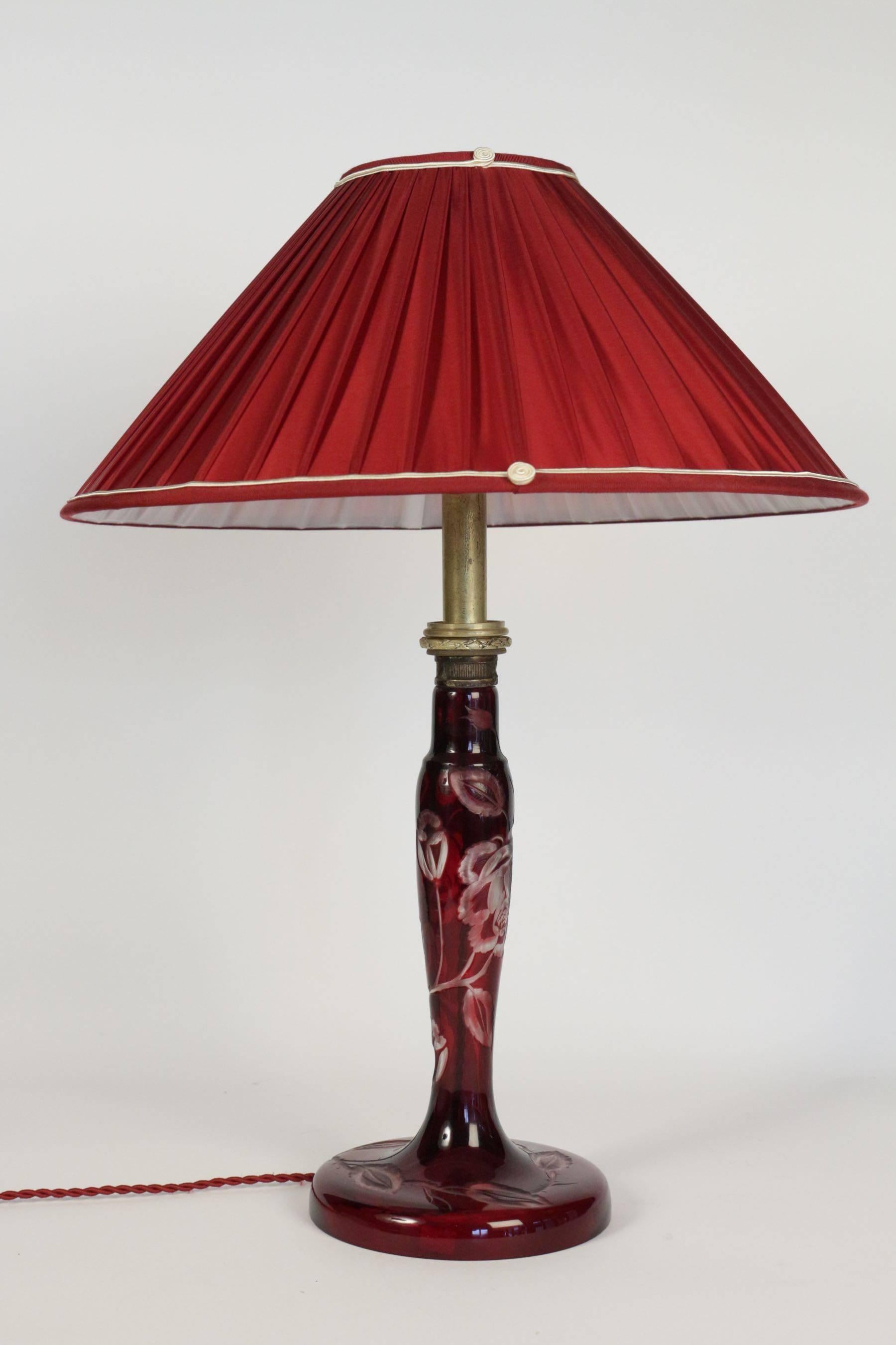A beautiful Art Nouveau table lamp in etched burgundy colored glass, circa 1900 with floral motifs.
  