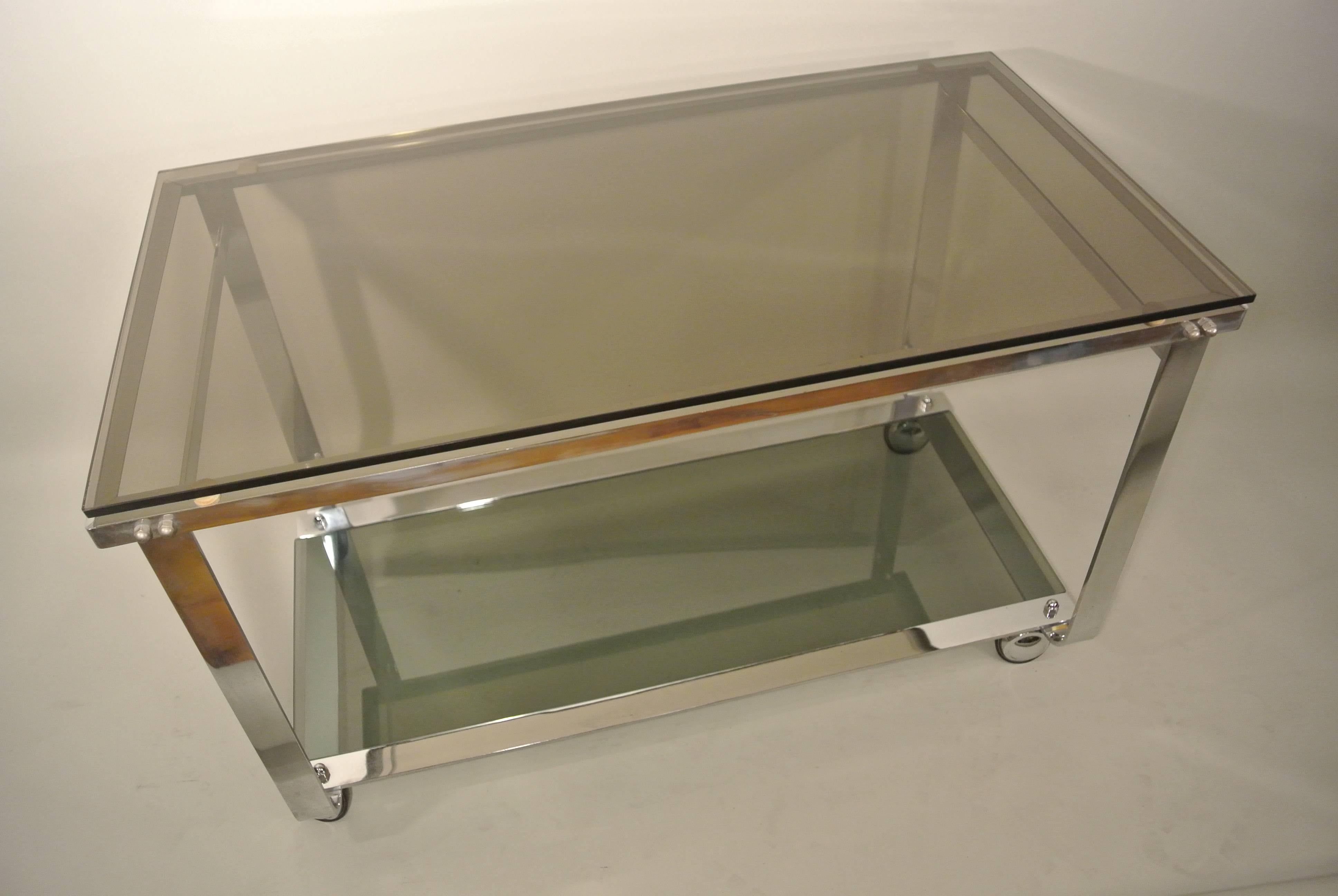 A Mid-Century chrome dessert or bar cart on wheels with tinted glass, circa 1970. Measures: Length 84cm x 45 cm wide x 52cm tall.
 