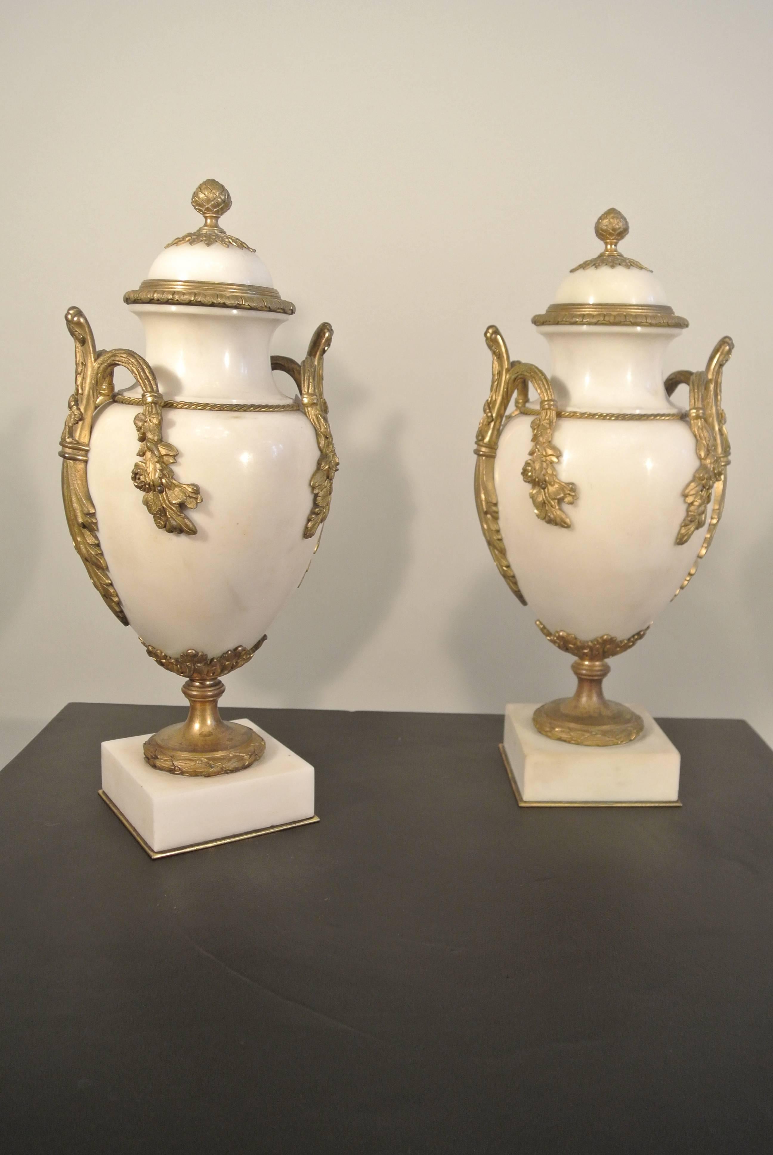 A beautiful pair of white marble jars with gold gilded bronze mounts,  19th Century
Measures: 32 cm x 15 cm x 12 cm.
 