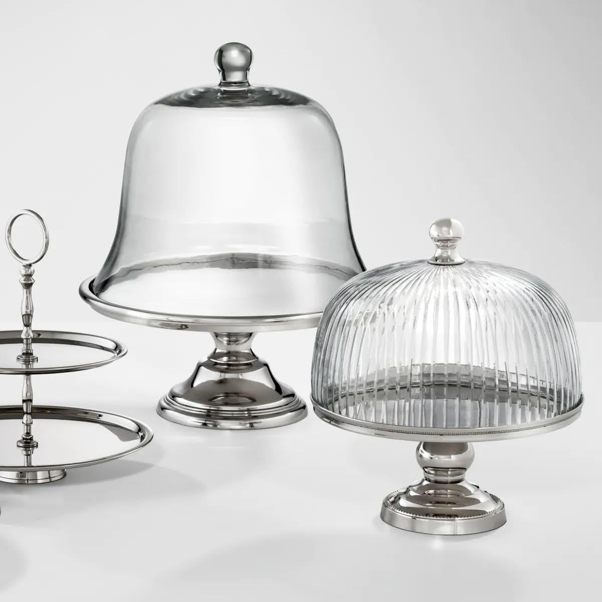 Coppia di alzate per dolci in metallo argentato e vetro trasparente.

Stupisci i tuoi ospiti con questa alzata per dolci.
Questa alzata per dolci ha una base in metallo argentato. Una bellissima cupola in vetro trasparente a coste ti permette di