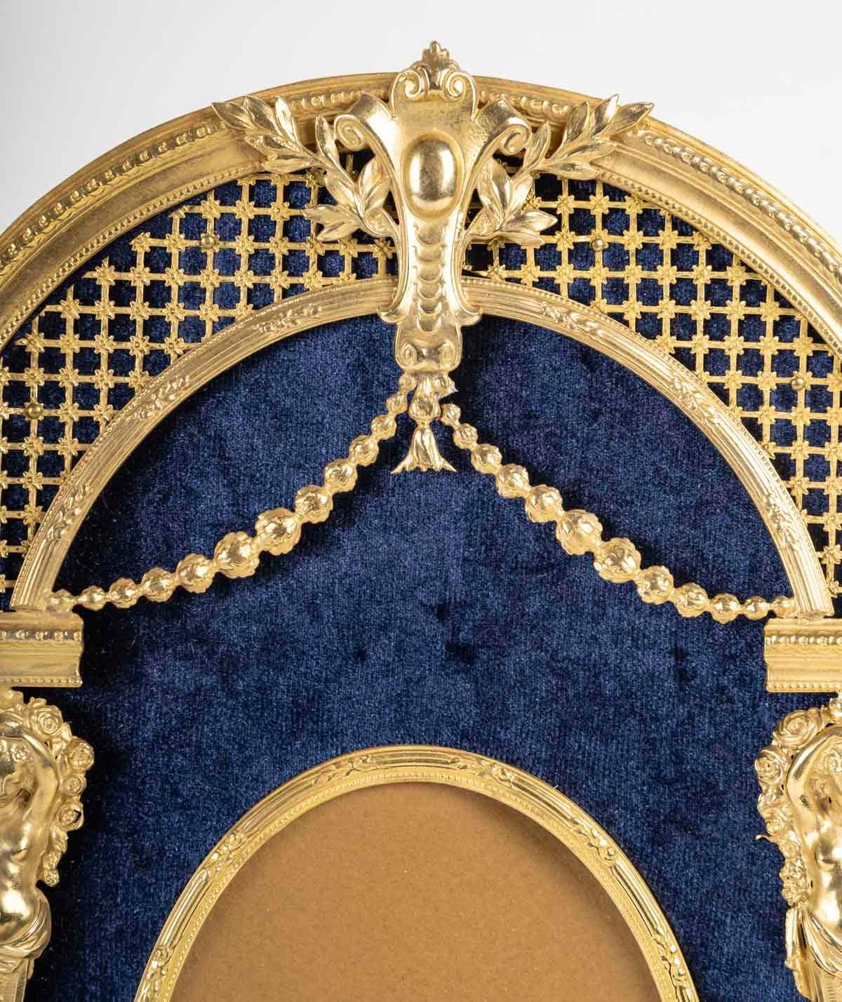 Photo frame, Napoleon III period, 19th century.

Photo frame in gilded bronze and blue fabric, Napoleon III period, 19th century, beautifully decorated.
H: 29cm, W: 18cm, D: 2cm