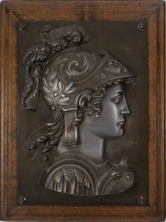 Pair of patinated metal bas-reliefs on a wooden display stand, 19th century.