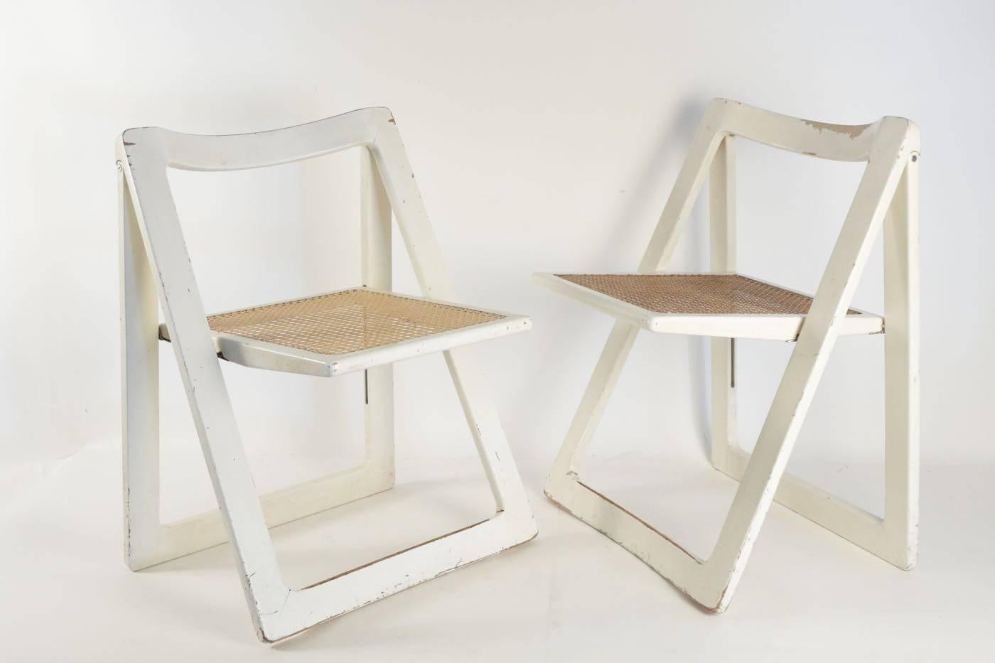 Three mid century modern folding chairs, circa 1960, With cane and white lacquer
