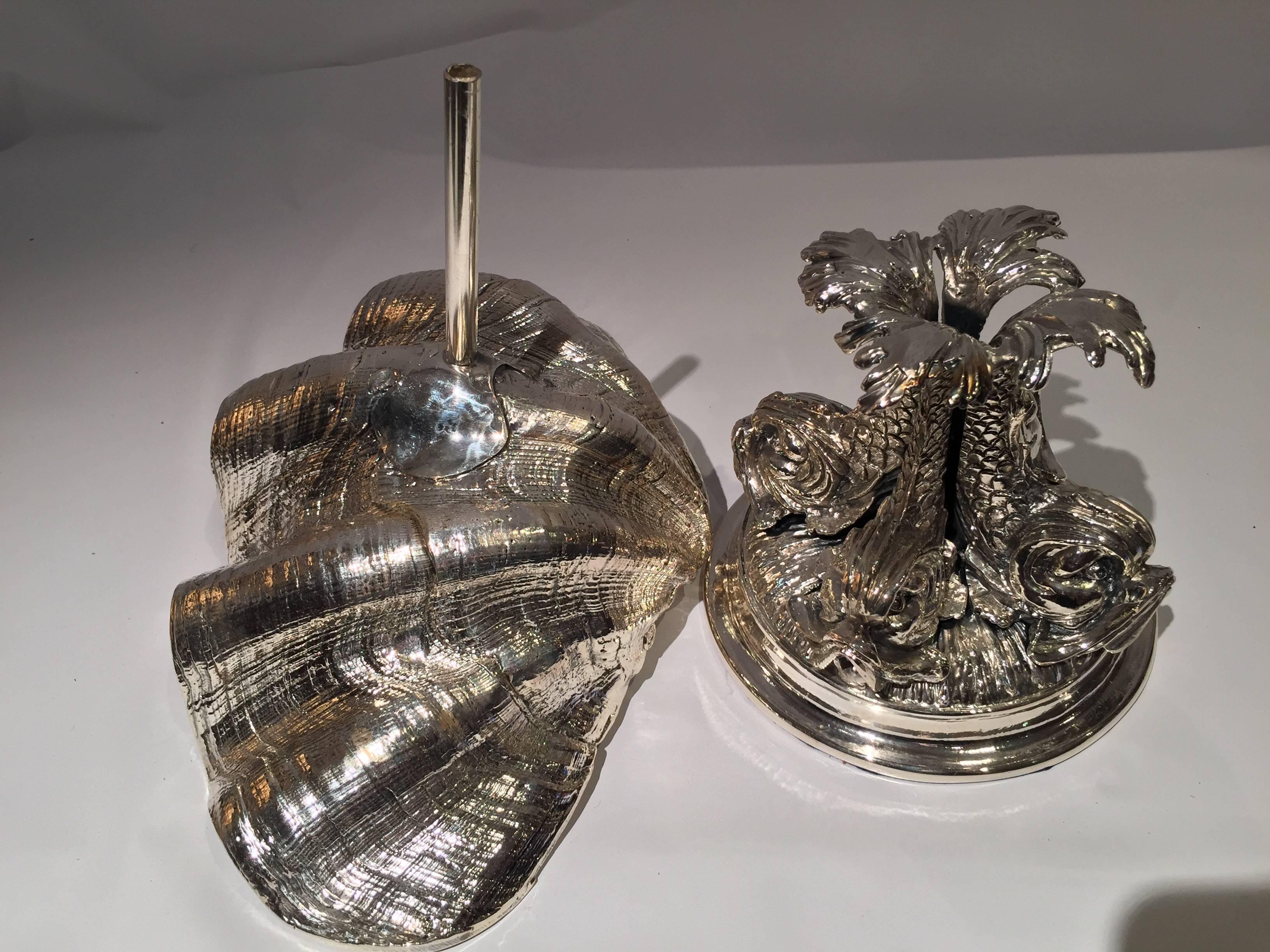 Creel and gow silvered resin clam shell mounted on a Cellini style triton base. This functional 925 Italian silver coated centrepiece is made in Rome.