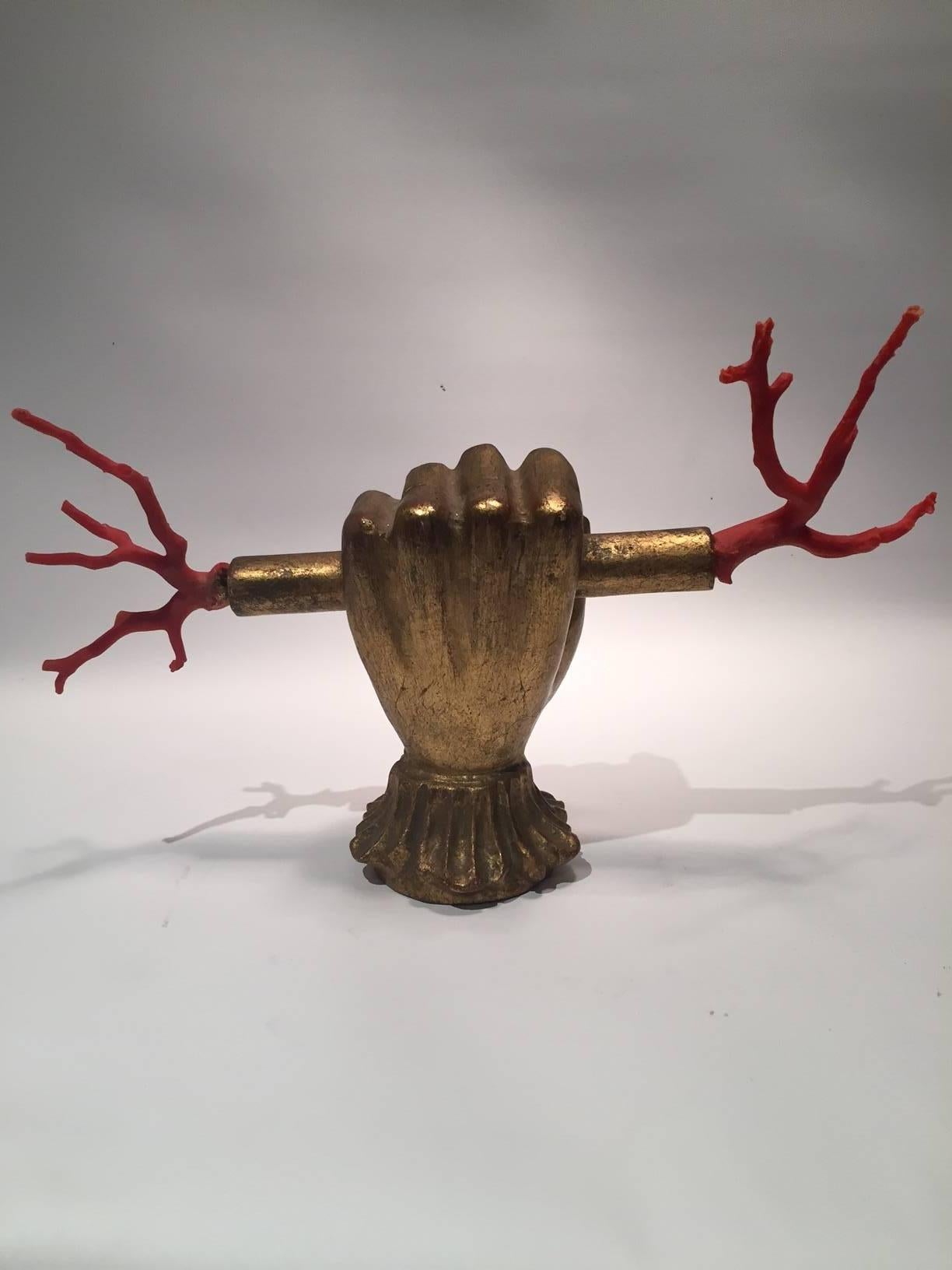 Italian gilded wooden hand clutching a red Mediterranean coral lightning staff, early to mid-20th century.
Mediterranean red coral has fascinated civilizations for thousands of years, given its intriguing nature, and has been classified as animal,
