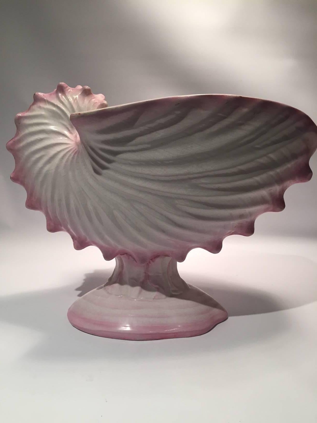 Wedgwood pink pearlware footed nautilus centerpiece with a pair of salt cellars in the form of dolphins mounted with clam shells. Each impressed with the Wedgwood stamp, 19th century 
Salt cellar dimensions are 6