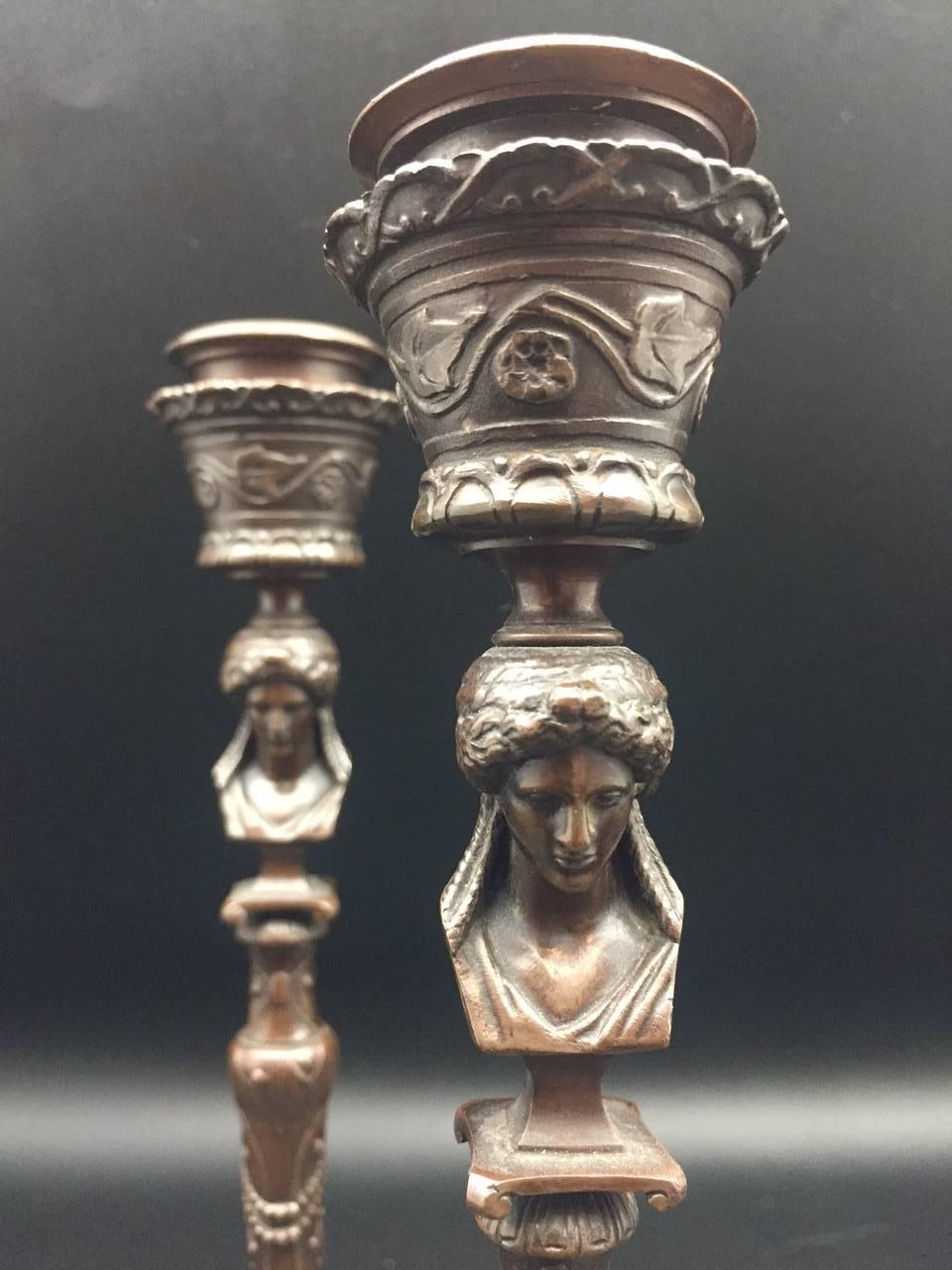 A beautiful pair of French 19th century bronze candlesticks with the Barbedienne foundry stamp. Each candlesticks are of pedestal form, decorated with swags and scrolls of vines, flowers and leaves, surmounted by the bust of Minerva, the Roman