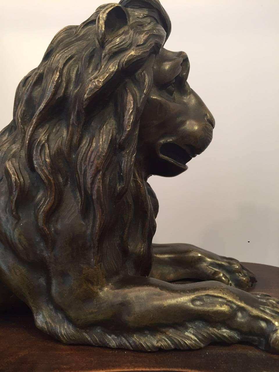 Large 19th Century French Grand Tour Bronze Recumbent Lion on Carved Wood Base In Good Condition In New York, NY