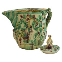 Cruche en majolique décorée de motifs représentant Bacchus, avec un fleuron figuratif, début du XXe siècle