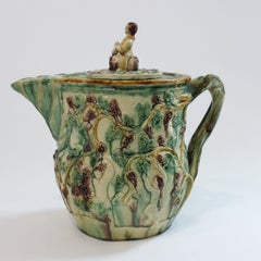 Cruche en majolique décorée de motifs représentant Bacchus, avec un fleuron figuratif, début du XXe siècle