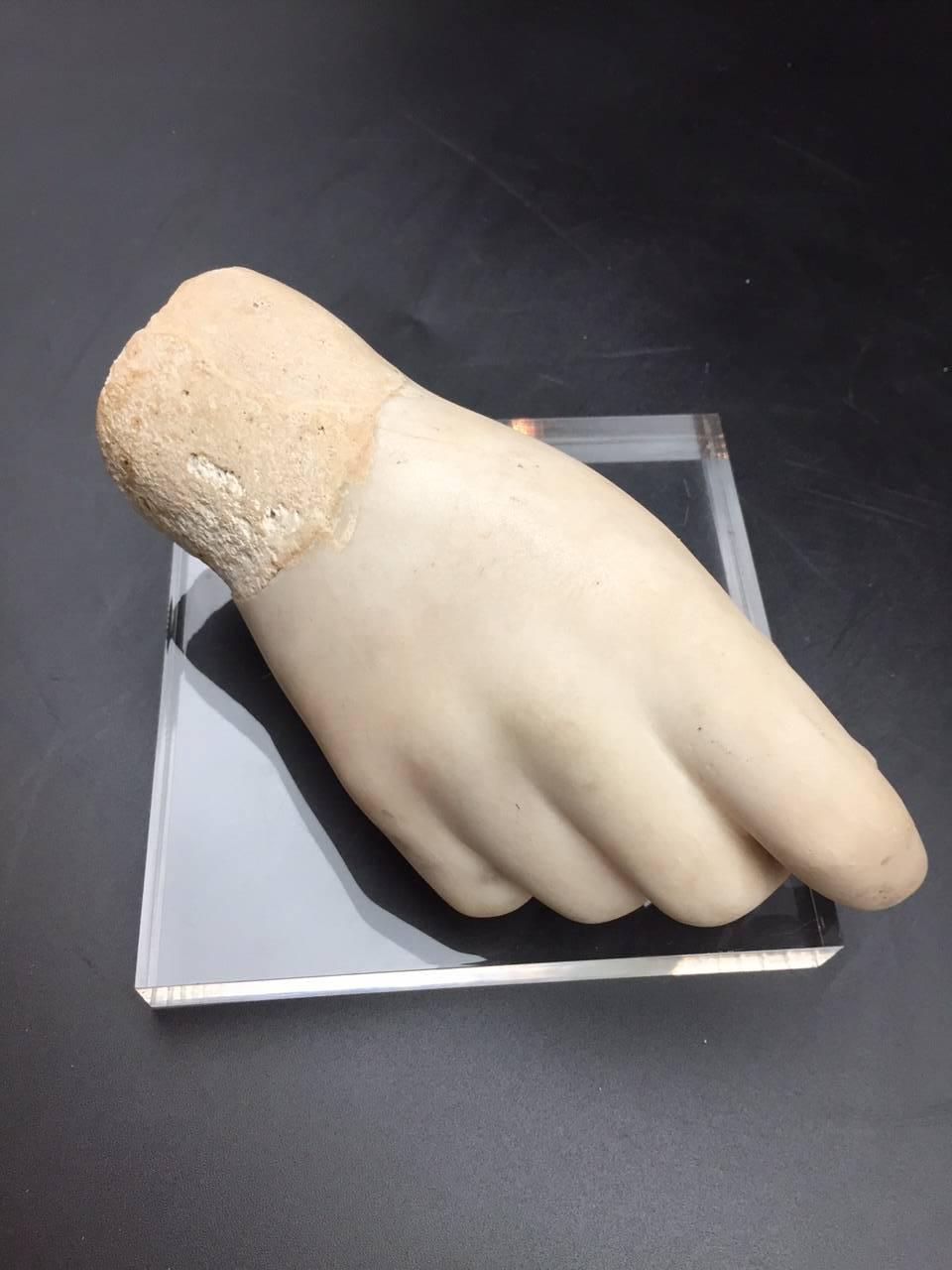 Beautifully sculpted French 19th century marble hand most probably part of a larger sculpture presented on a Lucite base. Visible restorations and breaks with the small and fourth fingertips missing but overall a fine piece.