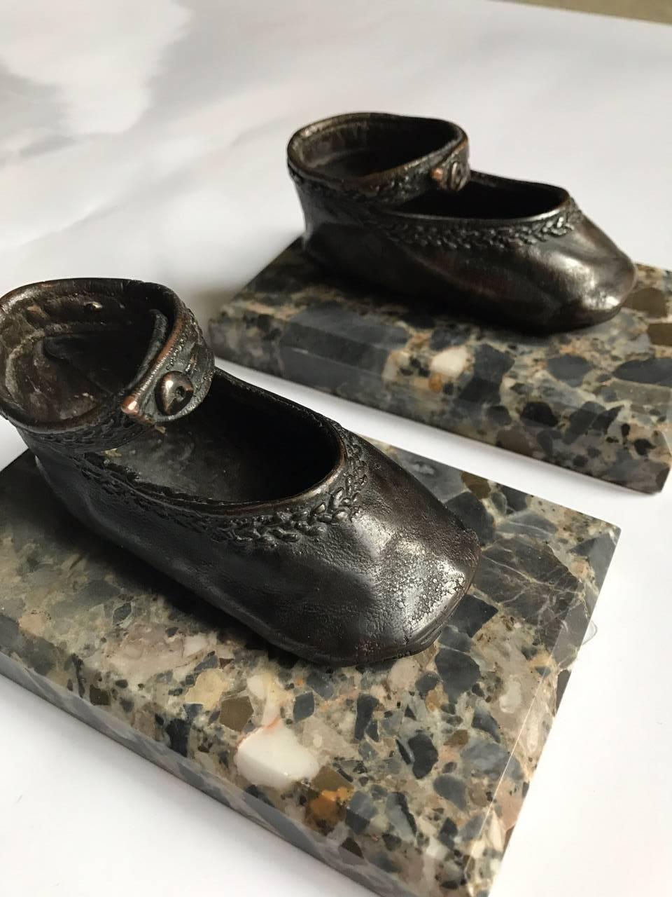Pair of early 20th century bronze ballerina style baby shoe paper weights mounted on marble bases.
