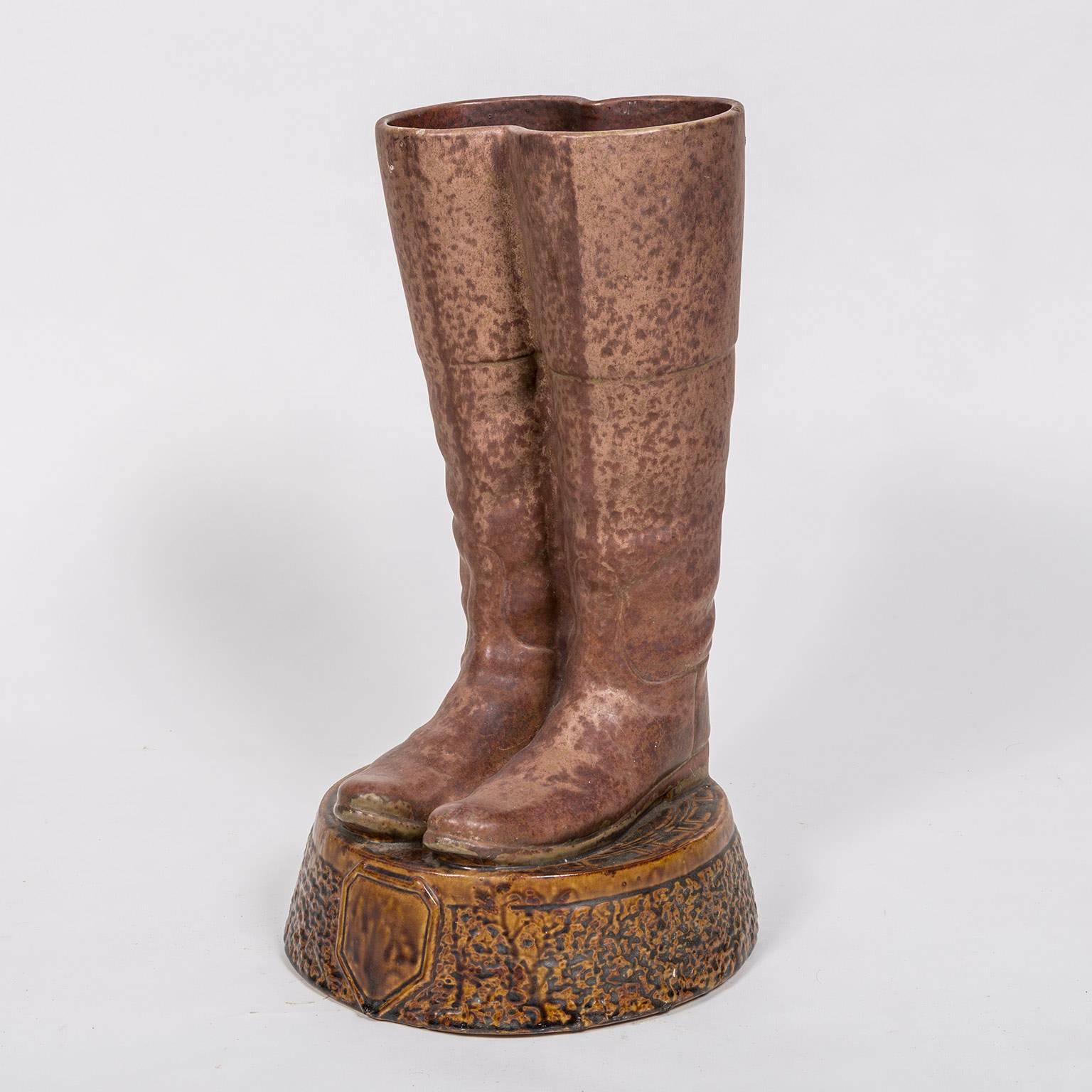 Unusual antique terra-cotta umbrella/cane stand in the form a pair of riding boots on a terra-cotta base.