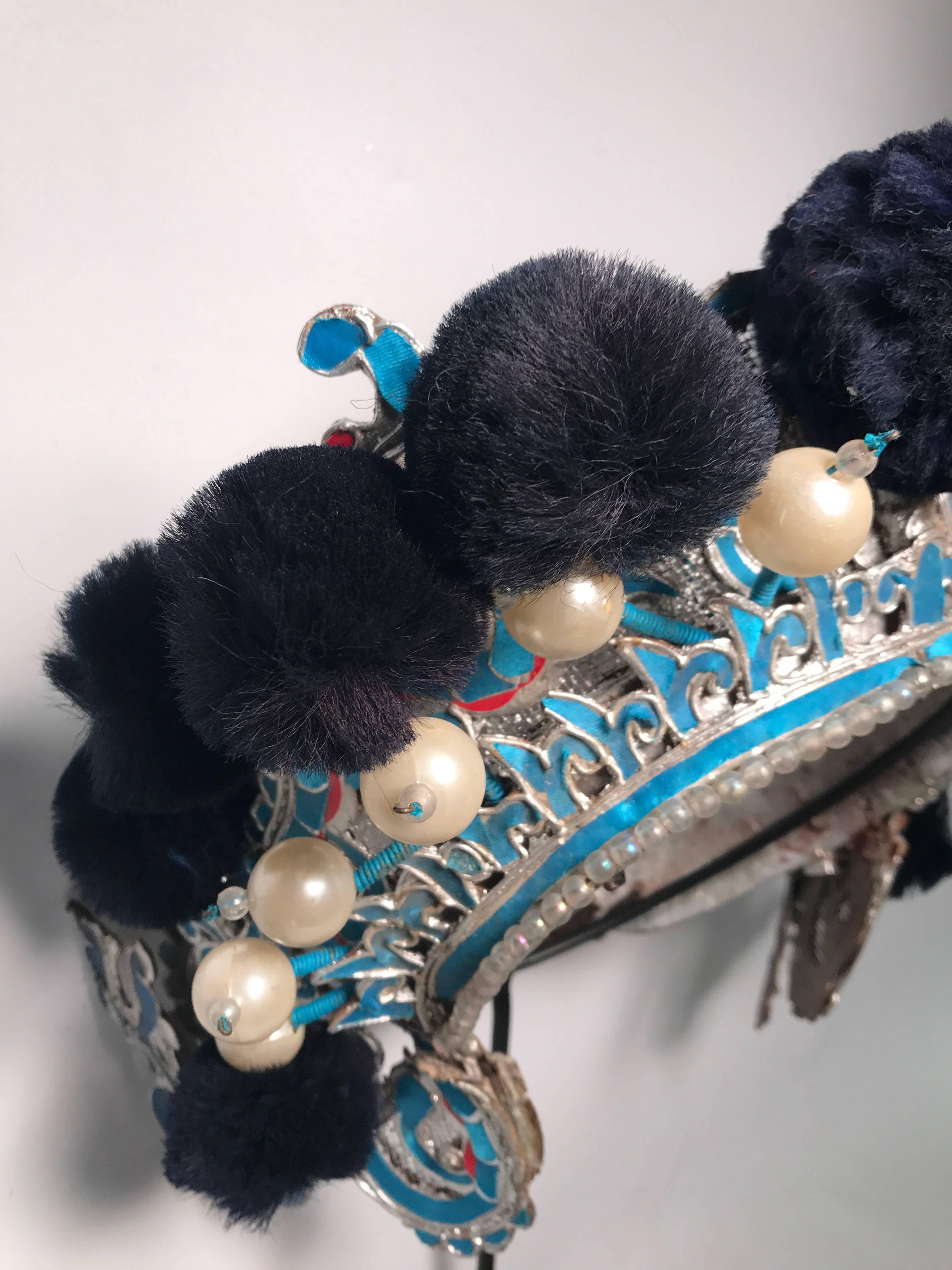 Chinese turquoise papier mache and midnight blue theatre headress, early 20th century, mounted on a custom, black painted metal base.