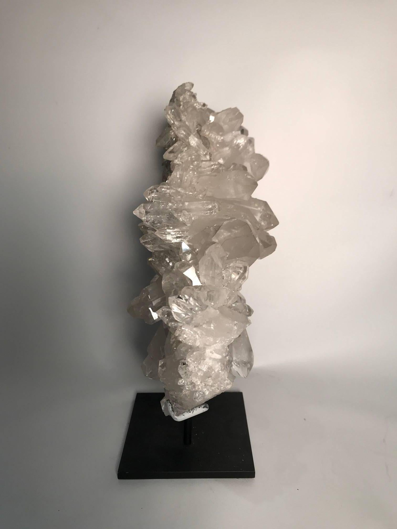 Double sided quartz rock crystal cluster mined in Arkansas, US, and custom mounted on a black metal base. Rock crystal, a form of quartz, has been used in jewelry and ornaments since antiquity, and is the purest form of quartz.