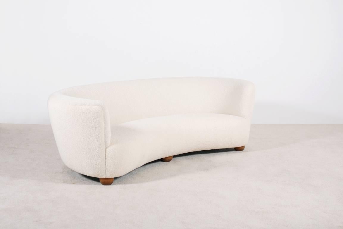One of our favorite piece. 

A very large (220 cm W) and well shaped three-seat curved sofa with three round wooden feet on the front. Very soft and comfortable seat. 

Perfect condition, newly upholstered with a high quality French wool
