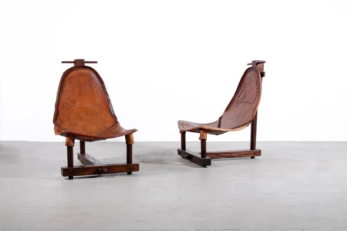 Rare and unusual pair of leather armchairs from 1950.

Strong brow leather with a beautiful patina.

Exotic wood frame.