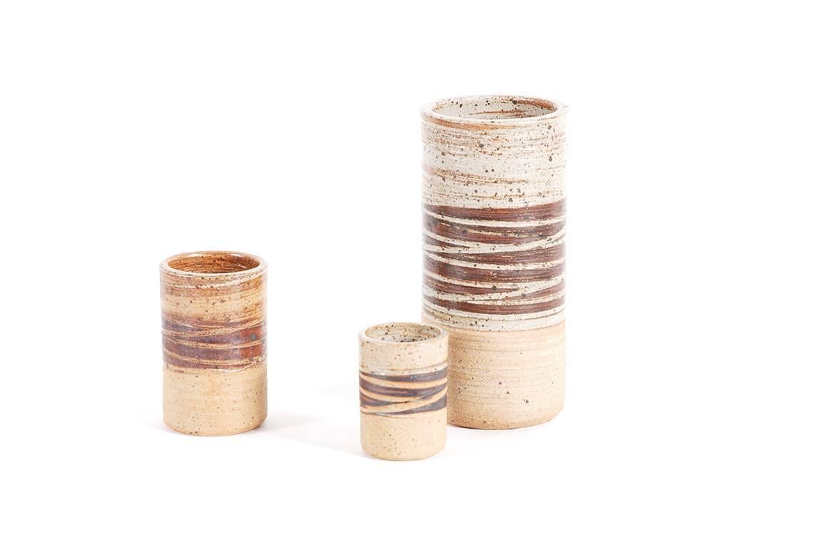 Set of three cylindrical glazed grog clay ceramics designed and handmade by the Danish ceramist Tue Poulsen, by the end of the 1960s.

Excellent condition.

Dimensions:
H 24.5 cm, D 12 cm
H 13 cm, D 8.5 cm
H 9 cm, D 7 cm

Excellent