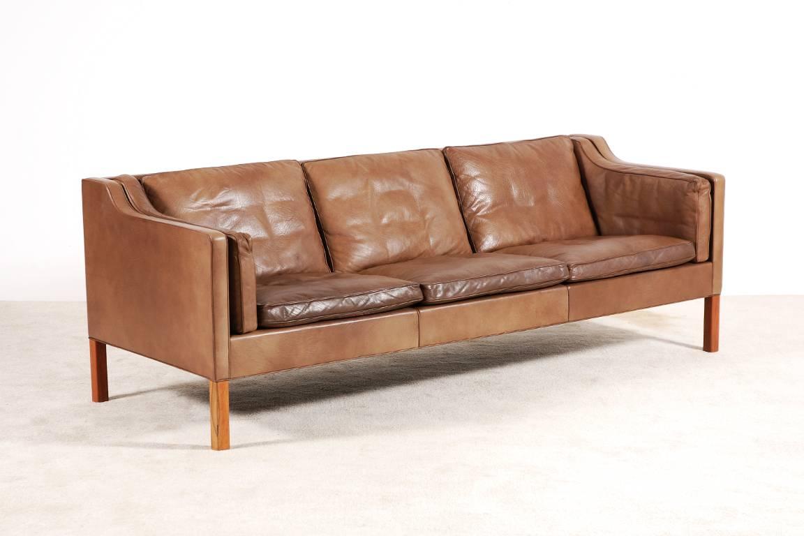 Very nice and iconic three-seat sofa model N°2213 designed by Børge Mogensen in 1962 especially for his own home and commercialised and produced a few years later by Fredericia Stolefabrik.
Here, the brown leather model, lovely patinated. Teak