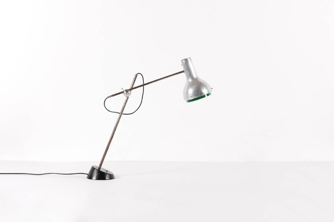 Rare table lamp by Gino Sarfatti. Model 573 produced by Arteluce from 1956.

Adjustable spotlight in anodized aluminium, with screen in green methacrylate. Arms in chrome-plated brass tubing. Conical base in cast iron lacquered in