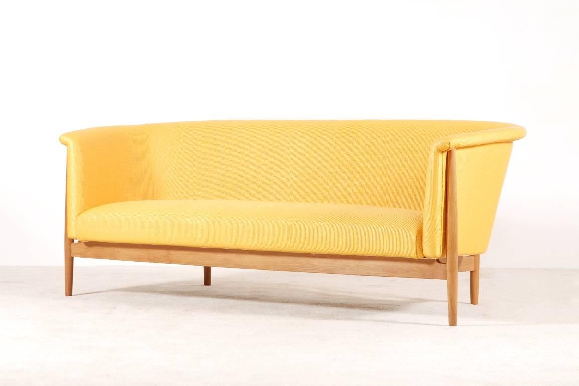 Very beautiful and rare three-seat sofa designed by Nanna Ditzel in 1952. Danish manufacture by Søren Willadsen.
Newly upholstered with high quality yellow fabric by the French house Nobilis.
Light oak frame.

Perfect condition.