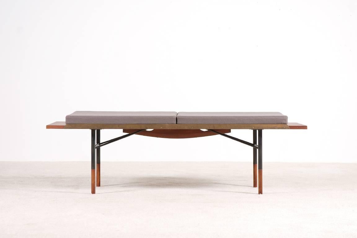 A beautiful architectural bench, also can be used as a low table, by the Danish designer Finn Juhl and manufactured by Borvirke in the 1950s.
Rectangular teak top with raised brass rails supported by a strutted steel base with teak-capped legs.