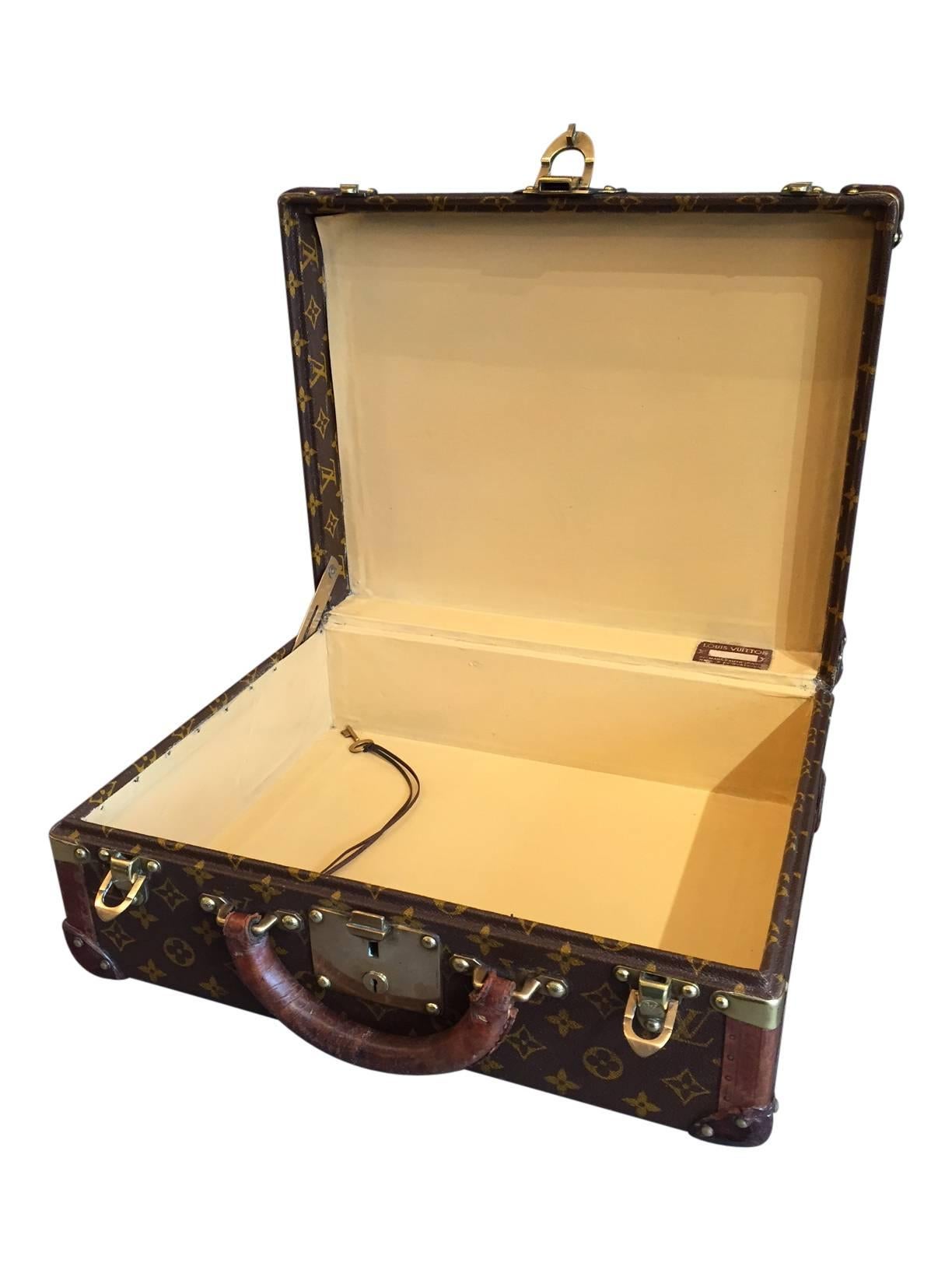 A vintage Mid-Century Louis Vuitton briefcase, circa 1950. It features leather corners and comes with its original key, a true rarity for any Louis Vuitton piece.