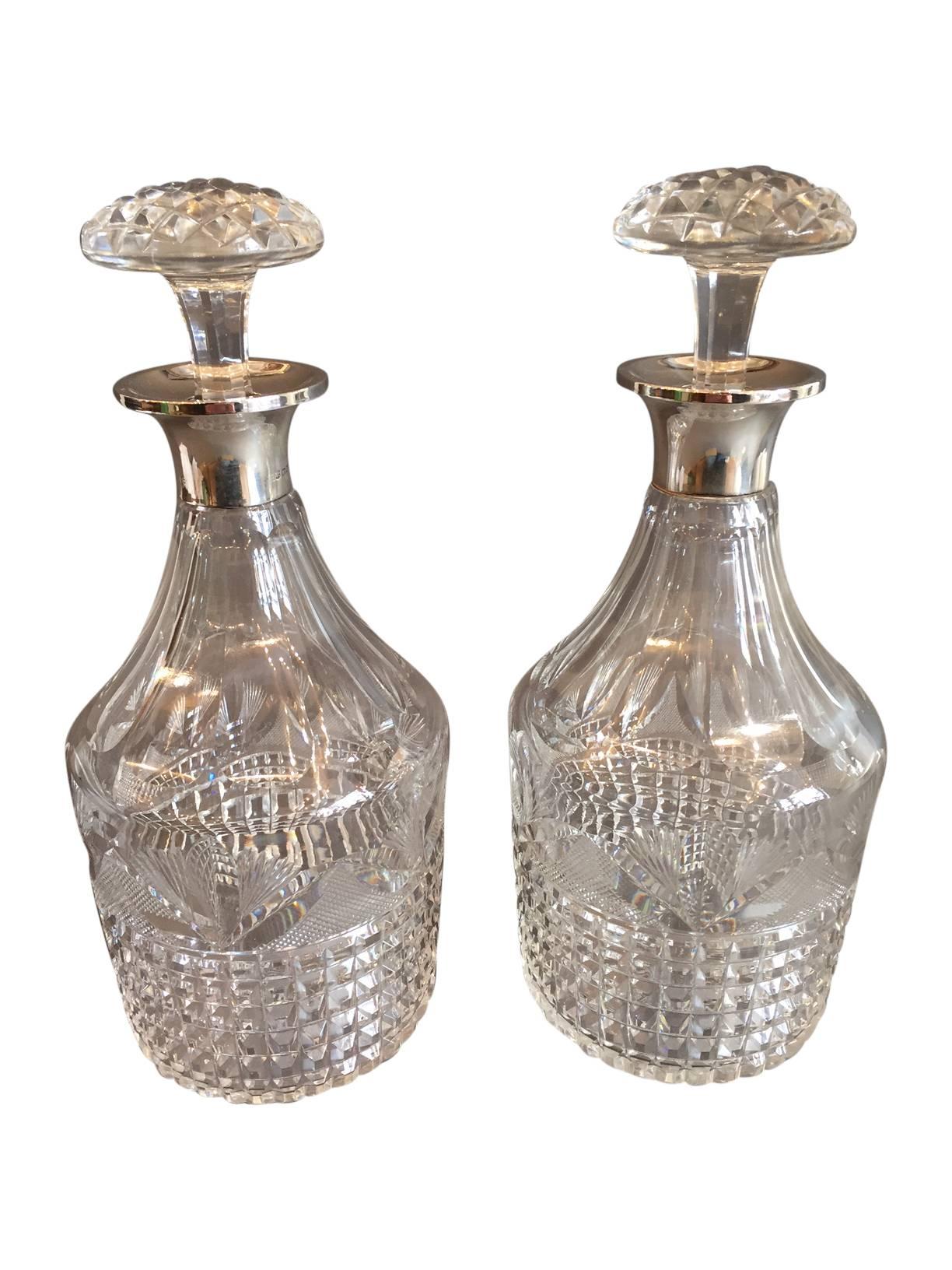 A beautiful pair of English sterling silver round-neck decanters, circa 1926.