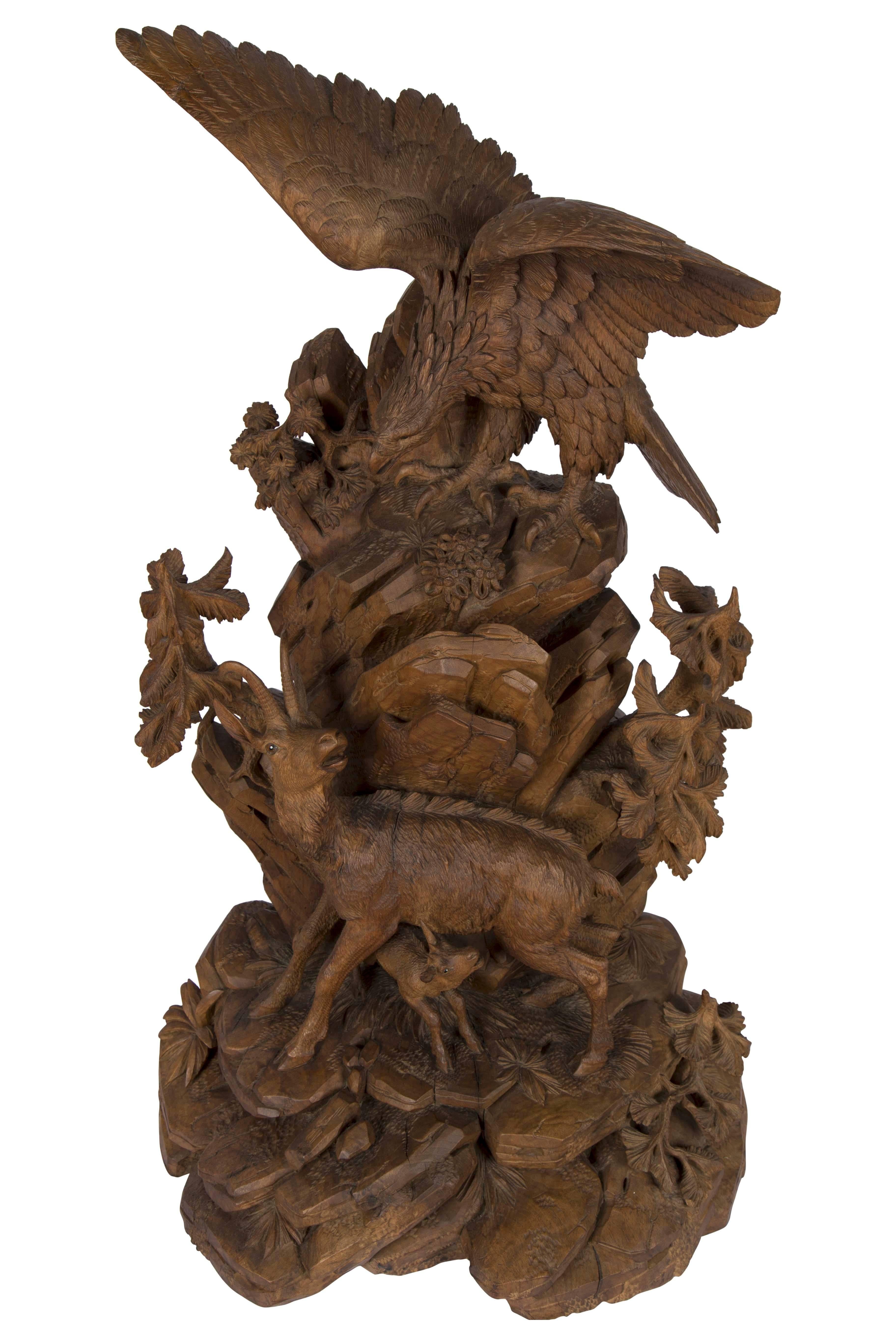 A finely carved Swiss “Black Forest” carved walnut sculpture, circa 1890. Portraying a Chamois protecting it’s young from a preying eagle. This exceptional carving is carved from one solid piece of walnut. Each of the animals has it’s original glass