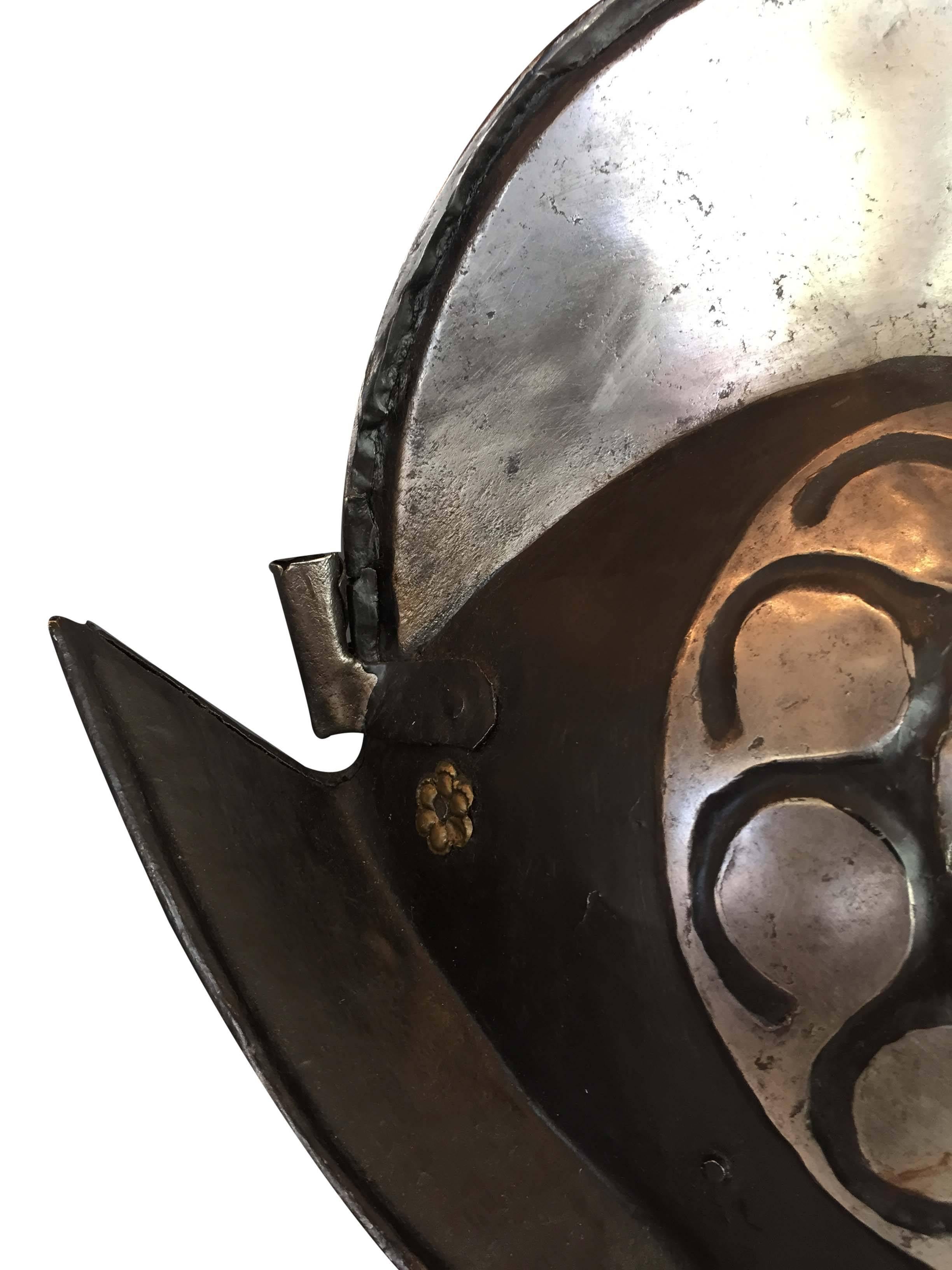An early 17th century black and white North German comb morion helmet. It features a beautiful hexafoil decoration on each side of the helmet.