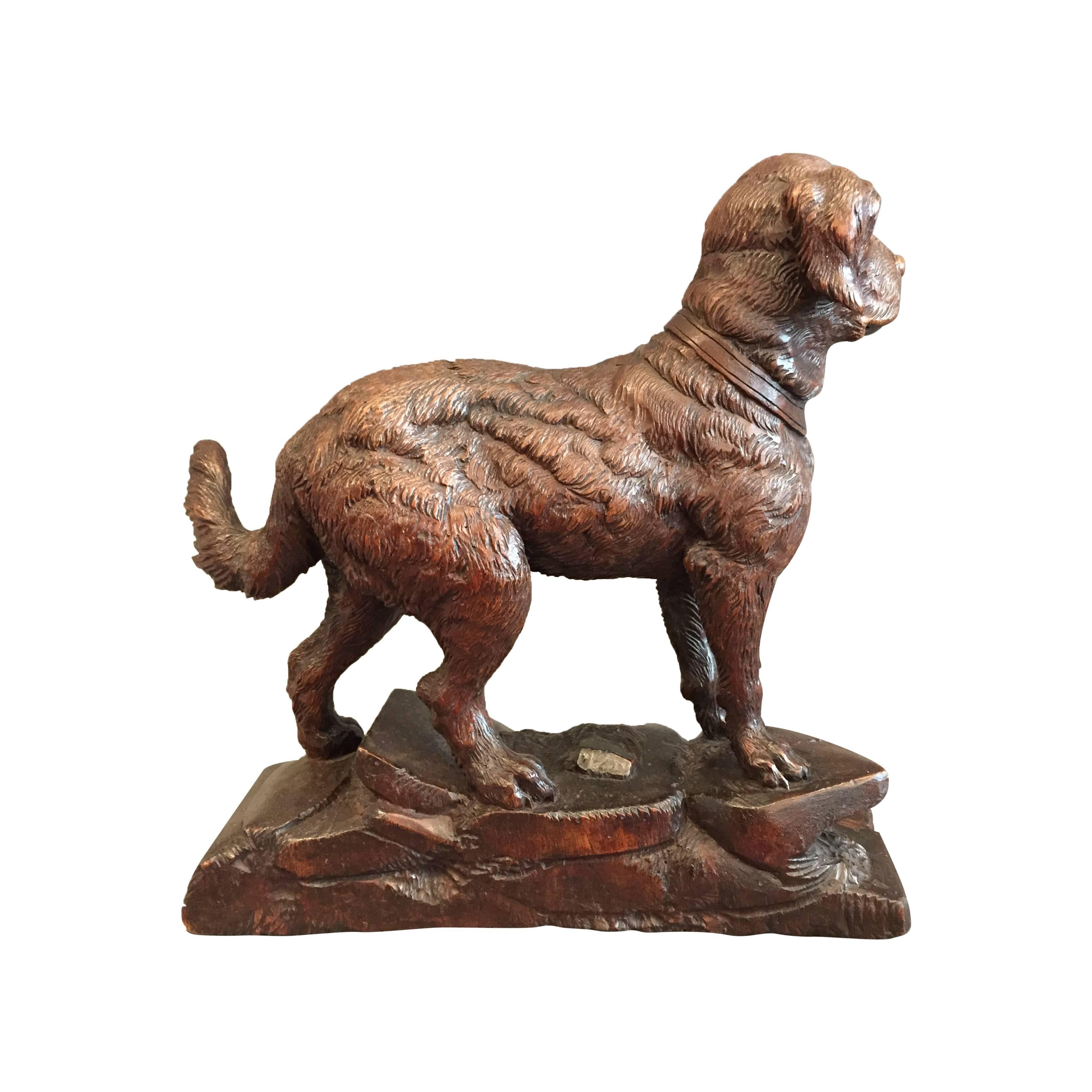 A beautiful walnut Swiss Black Forest carving, modeled after an alert dog standing on rocks.