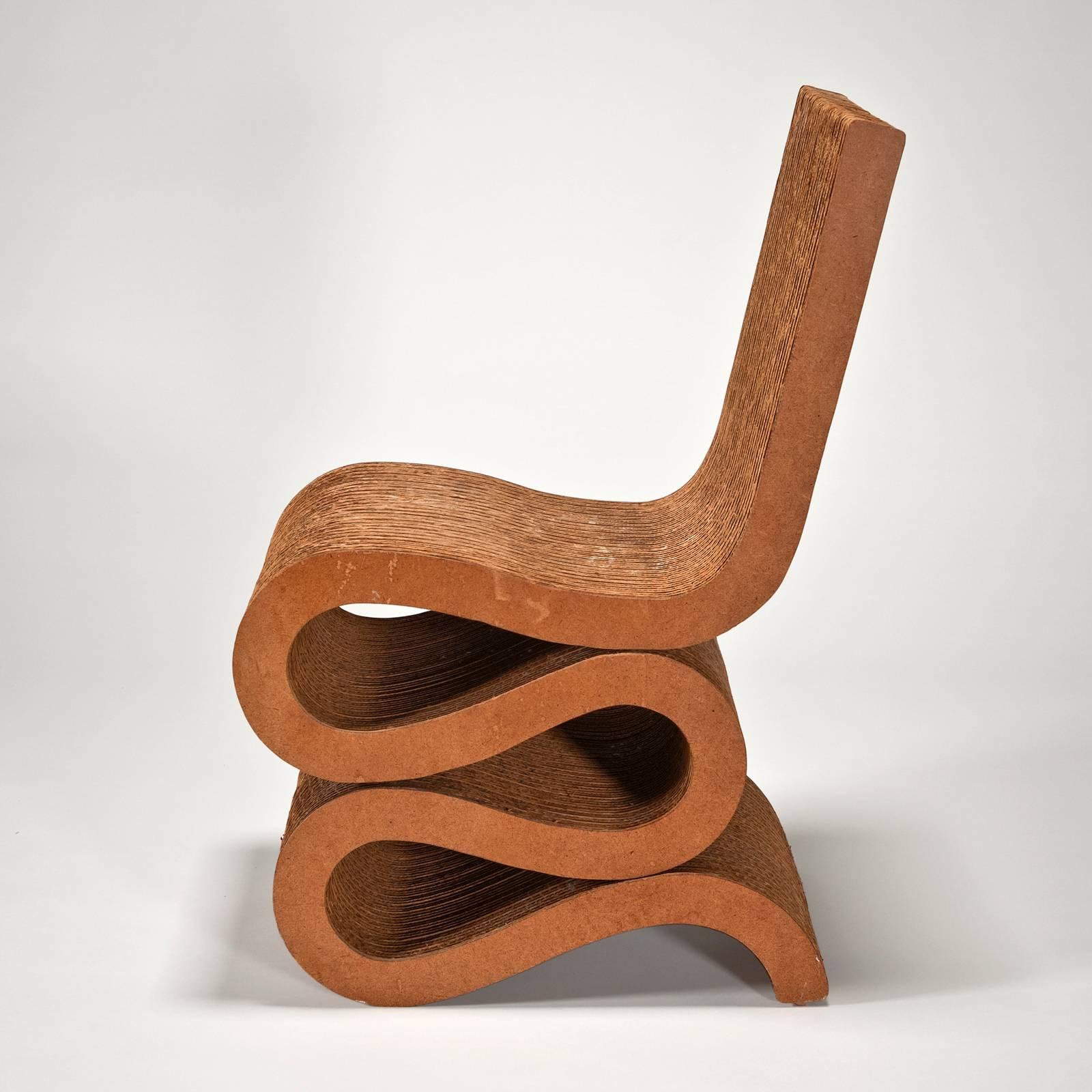 The Wiggle Side Chair, architect Frank O. Gehry's best-known design in cardboard, was designed in 1972. This example was produced by Easy Edges, Inc for Bloomingdale's. The cardboard seat and back have a beautiful suedelike patina. The condition is