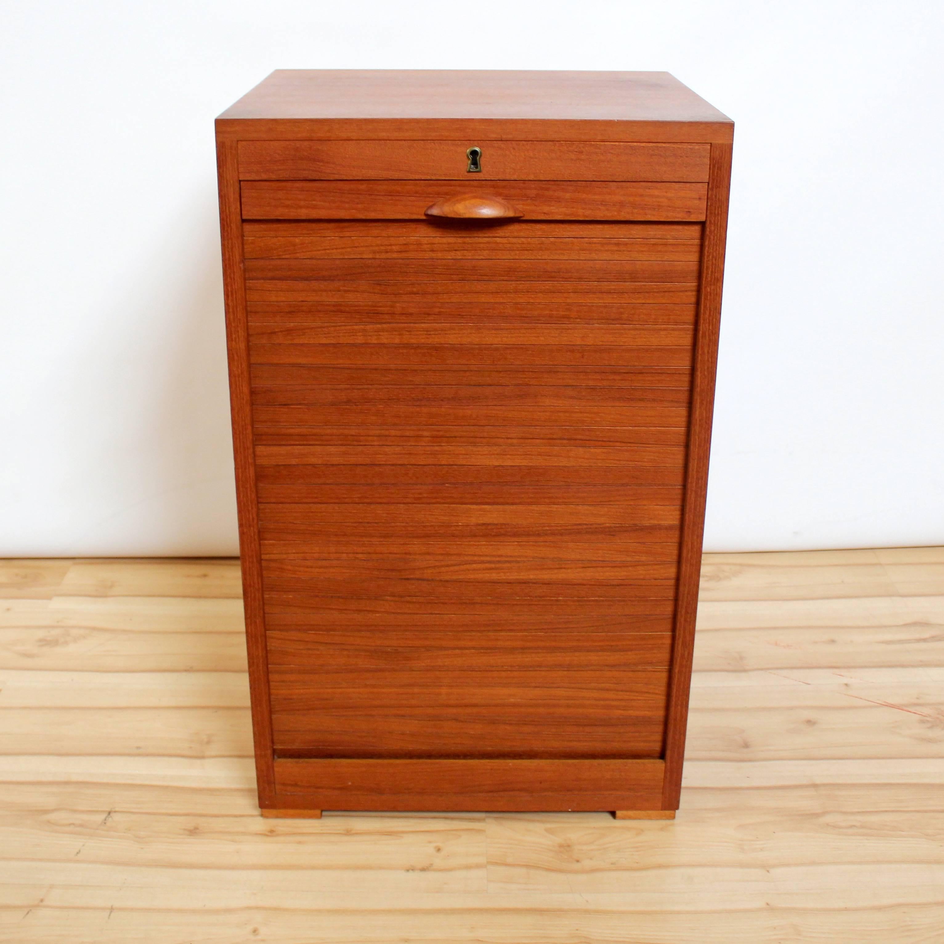 1960s Danish modern teak flat filing cabinet by Frej-Odense. Cabinet features locking tambour door with key and six birch filing drawers. Marked 