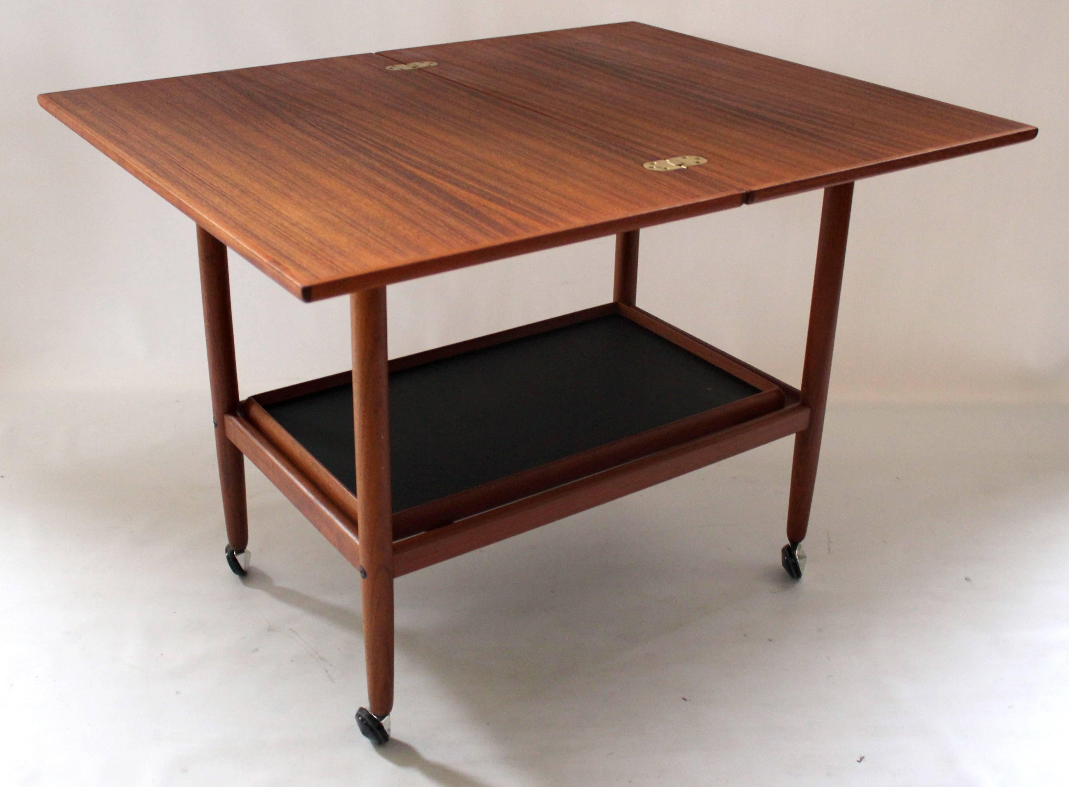 1960s Danish modern teak bar cart with convertible top that rotates and opens. When closed, the top measures 17.5