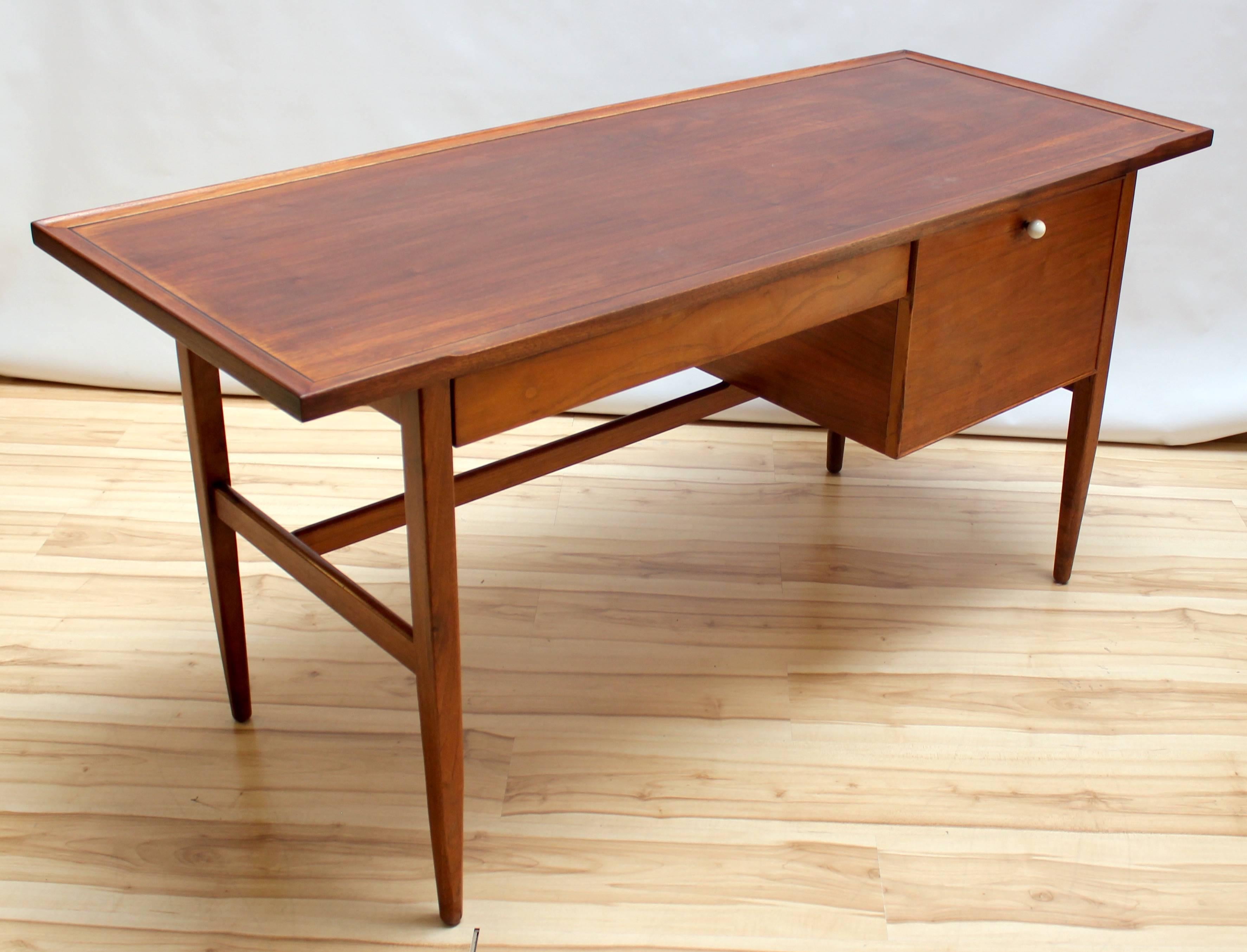 1950s Drexel Declaration desk designed by Kipp Stewart and Stewart McDougall. Desk has one drawer and one filing drawer with white porcelain pull. Very small loss of veneer on back corner.
