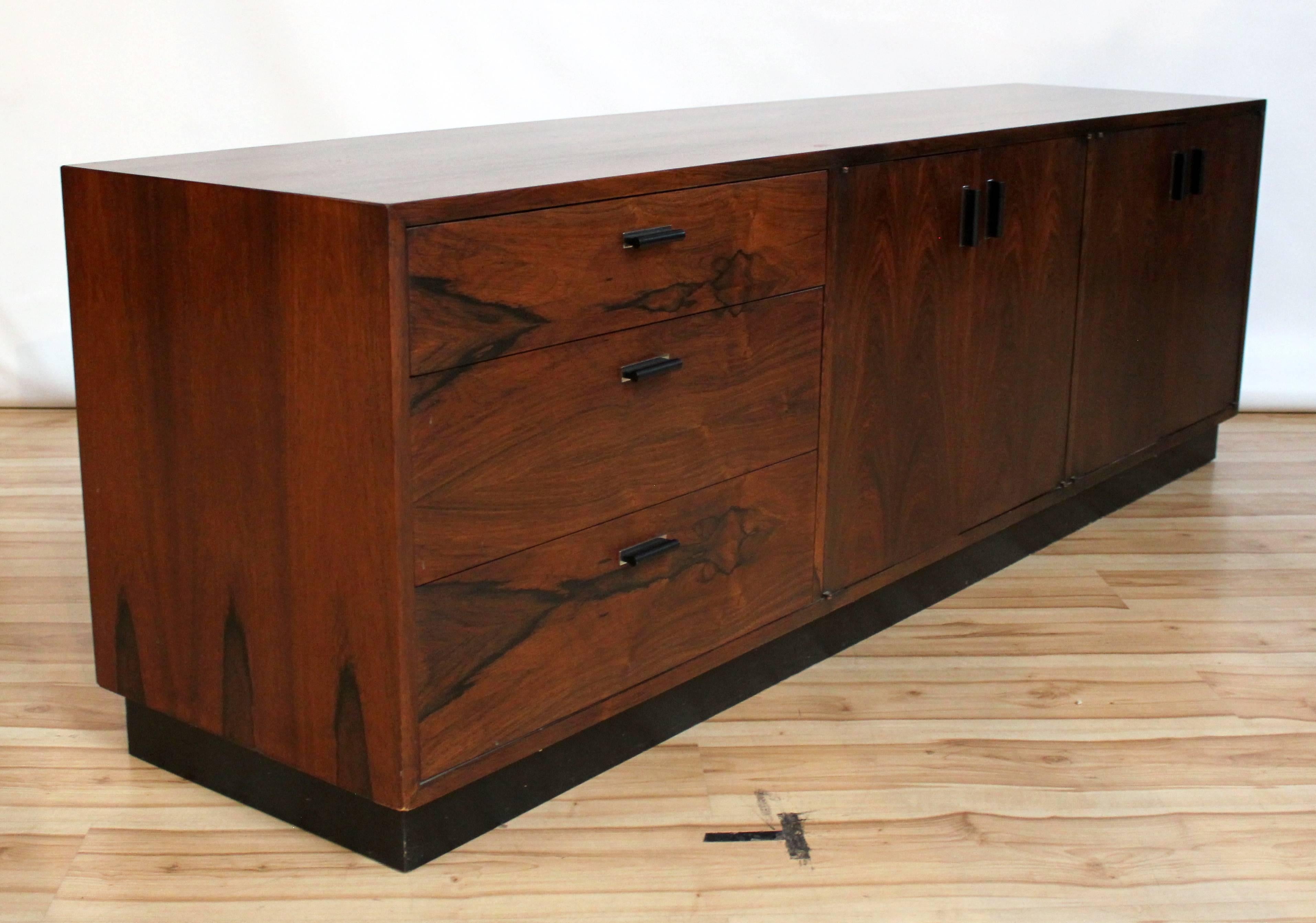 1950s Brazilian rosewood credenza by Harvey Probber on inset black plinth base. The credenza features three drawers and two cabinets with adjustable shelves. 