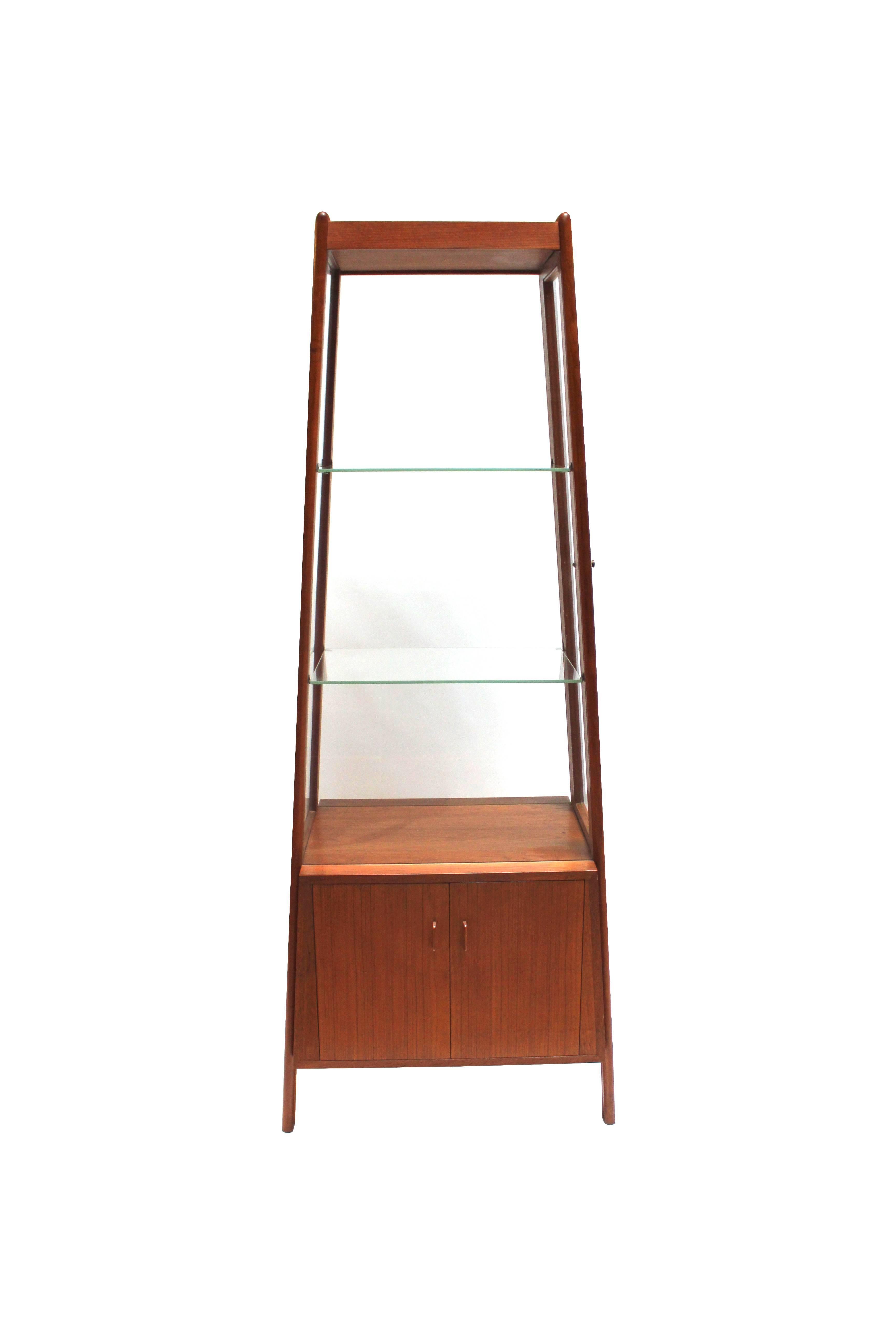 Rare 1950s Danish modern tapered teak and glass curio cabinet or vitrine designed by Hans Wegner with two glass shelves and storage in bottom unit. Most likely made as a special order.