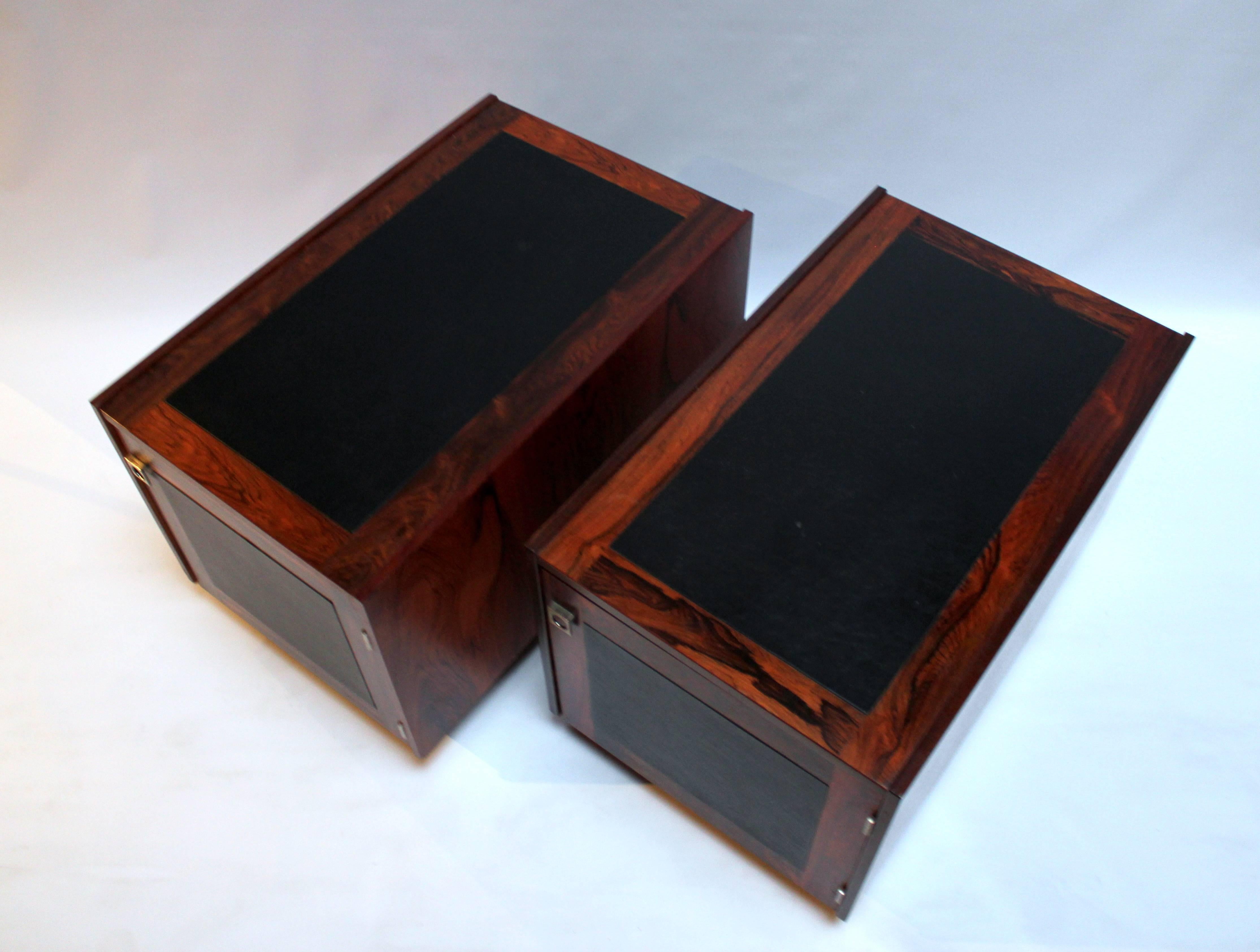 Pair of 1960s Danish modern rosewood and leather side tables by Bornholm. Tables have doors on one side with metal pulls and open storage on other end that's ideally sized for LP storage. Price is for the pair.