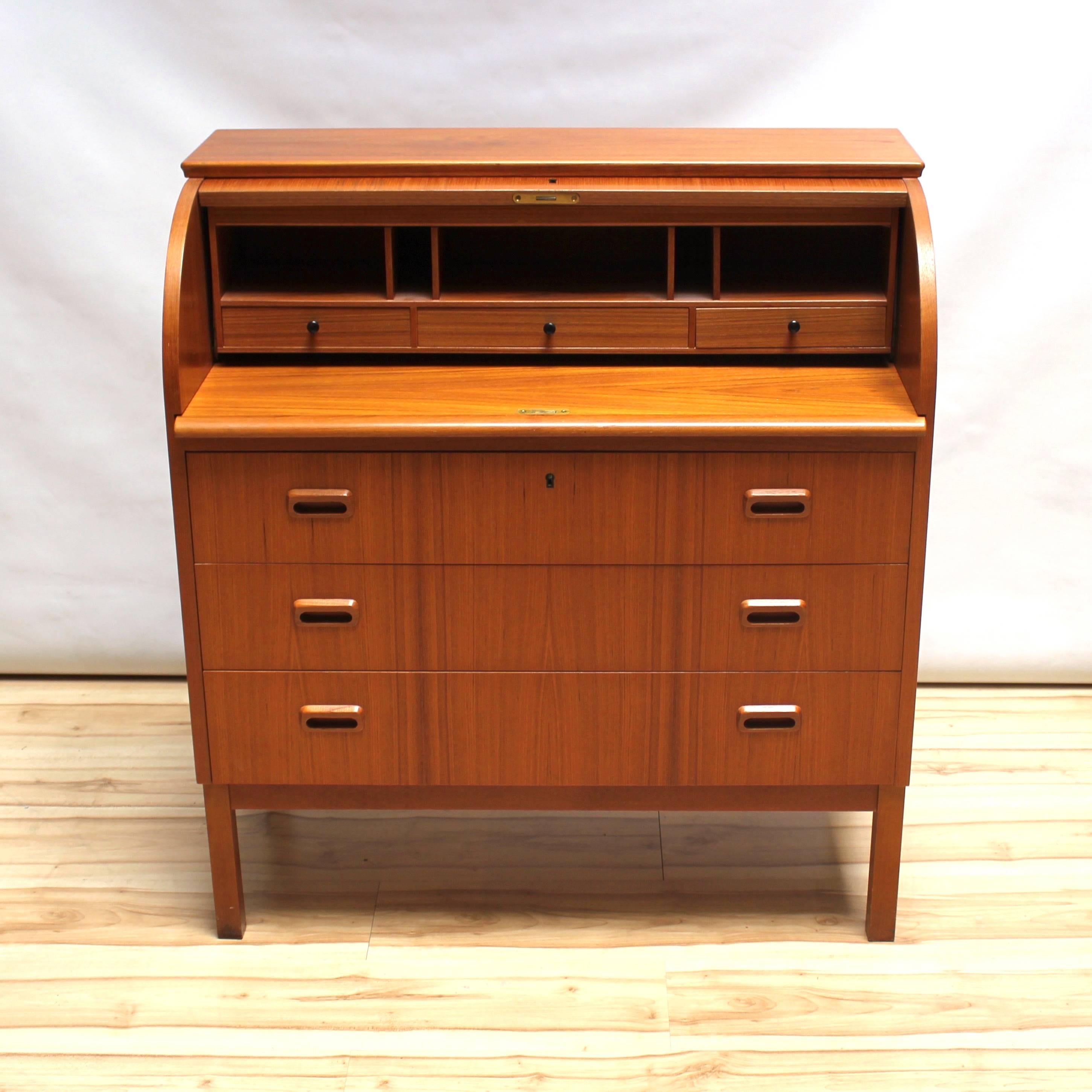 1960s Scandinavian teak secretary desk, made in Sweden. The desk has three drawers, a locking roll top front, and an extendable writing surface, as well as smaller drawers and slots for organizing. In excellent condition, with a some evidence of sun