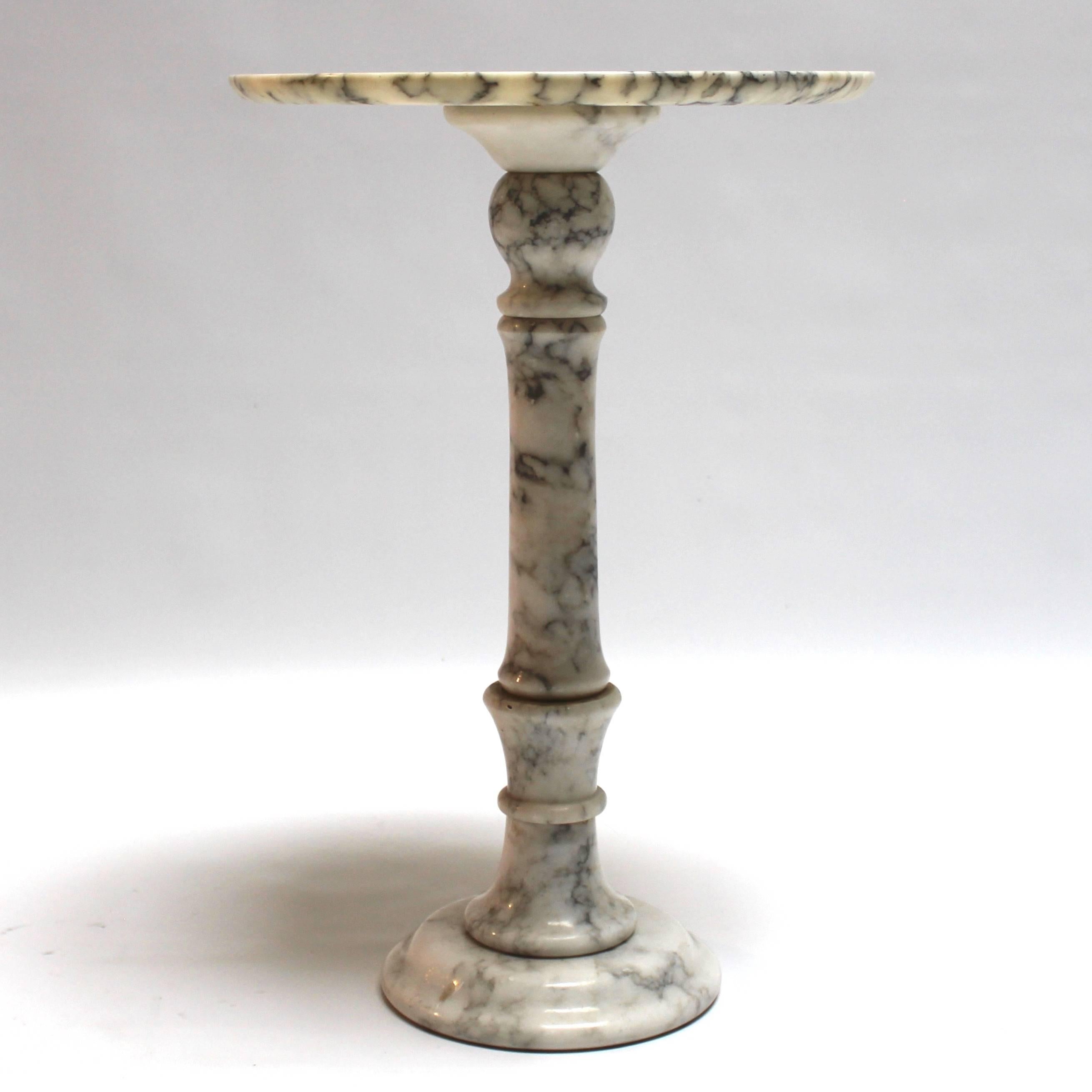 Vintage Carrara marble round side table or plant stand, made in Italy. With a delicate sculptural pedestal base, the table is an ideal transitional piece, mixing well with modern, traditional, or contemporary pieces.