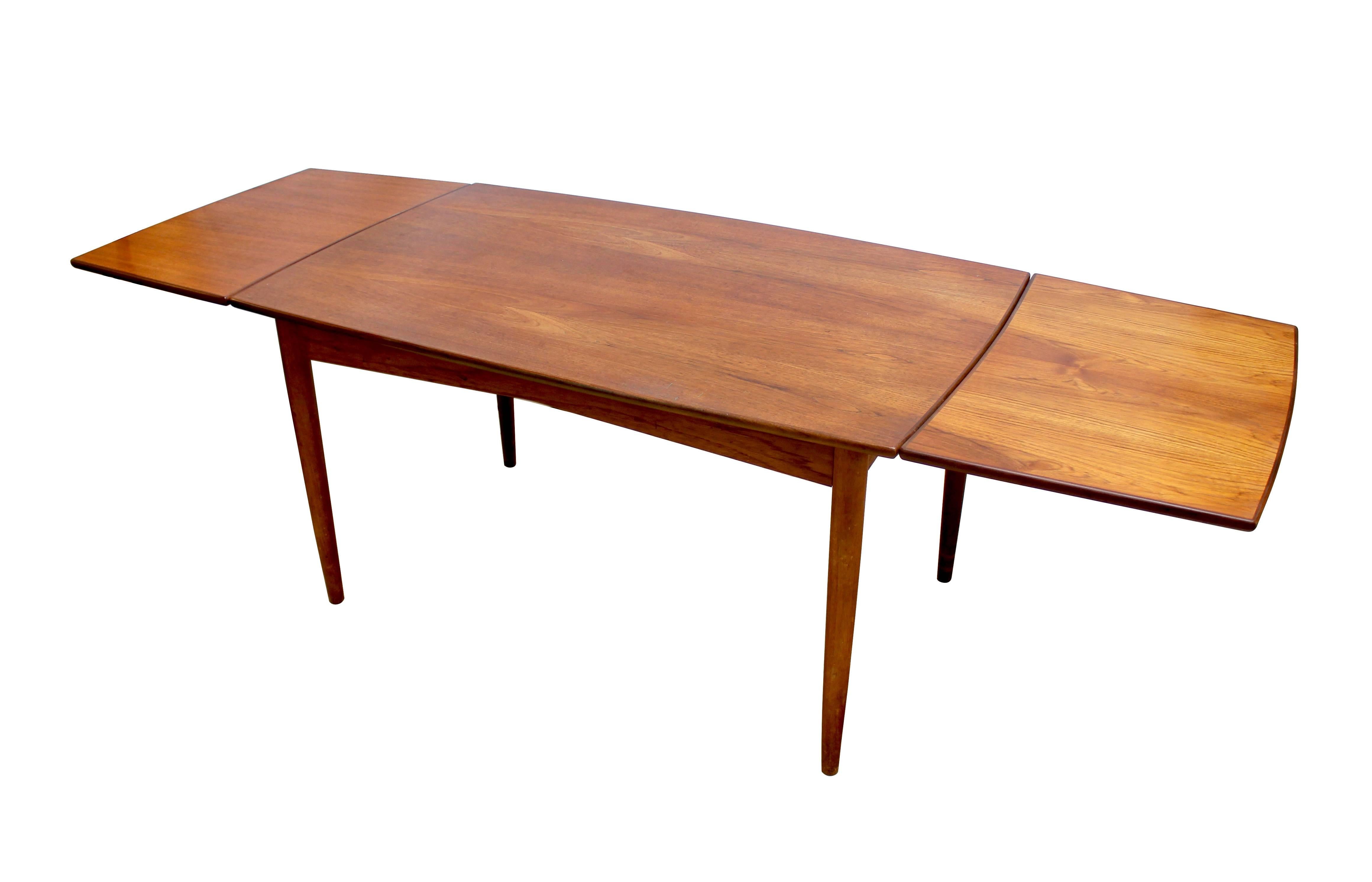 1960s Danish modern teak draw-leaf dining table in excellent condition with an elegant tapered design. The table measures 54.5