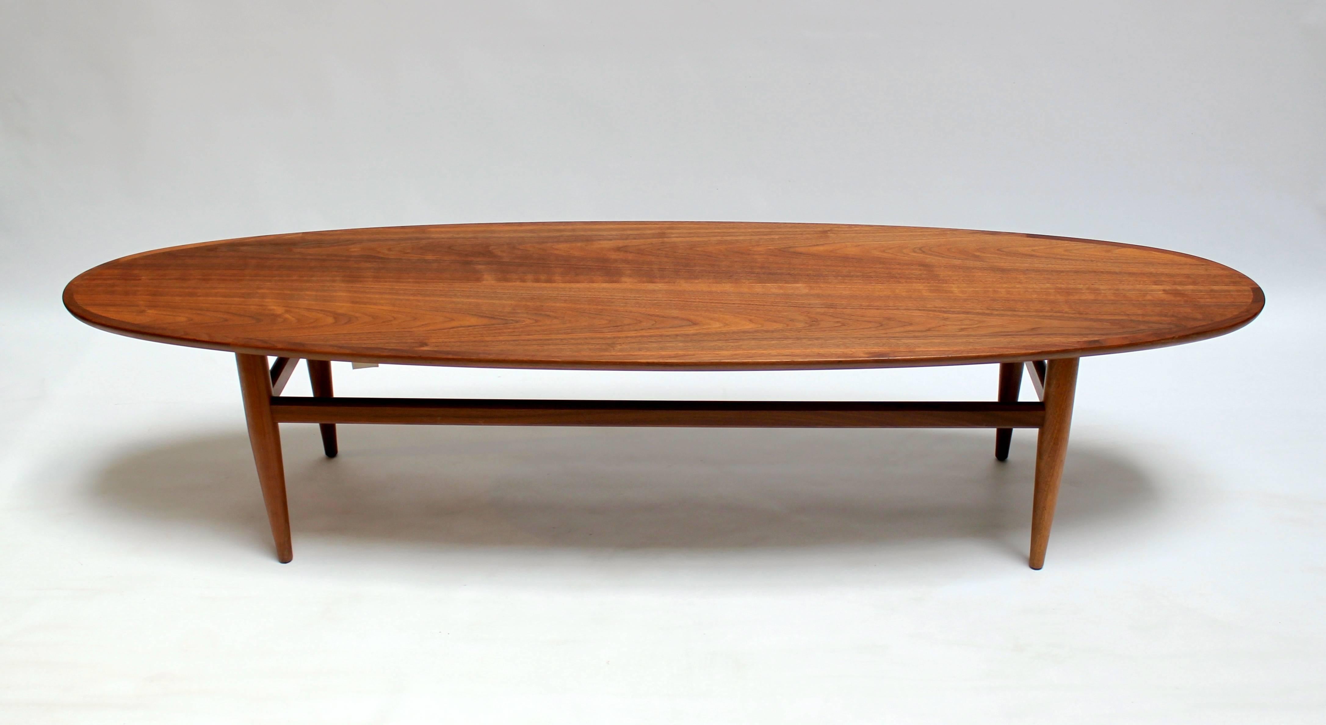 Mid-Century Modern walnut surfboard coffee table by Heritage. Slightly narrower than the standard surfboard coffee table, this piece more delicate and graceful lines than most similar pieces. The top has been professionally refinished, and is in