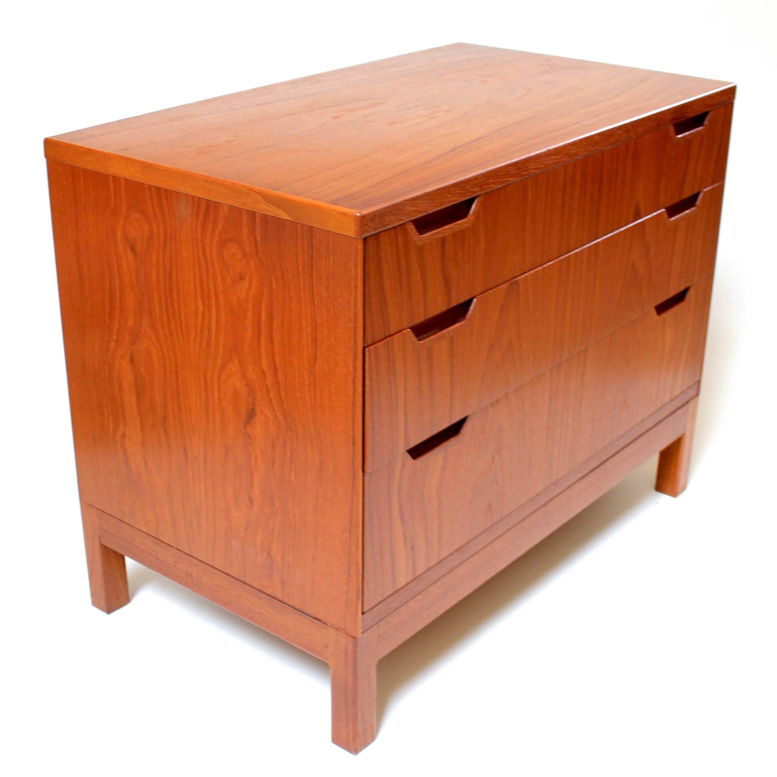 1960s Danish modern teak chest of drawers by Svend Langkilde for Langkilde Mobler. This is a beautifully designed three-drawer small dresser or nightstand with elegant sculptured pulls and matching grain on drawers. Possibly produced for Illums
