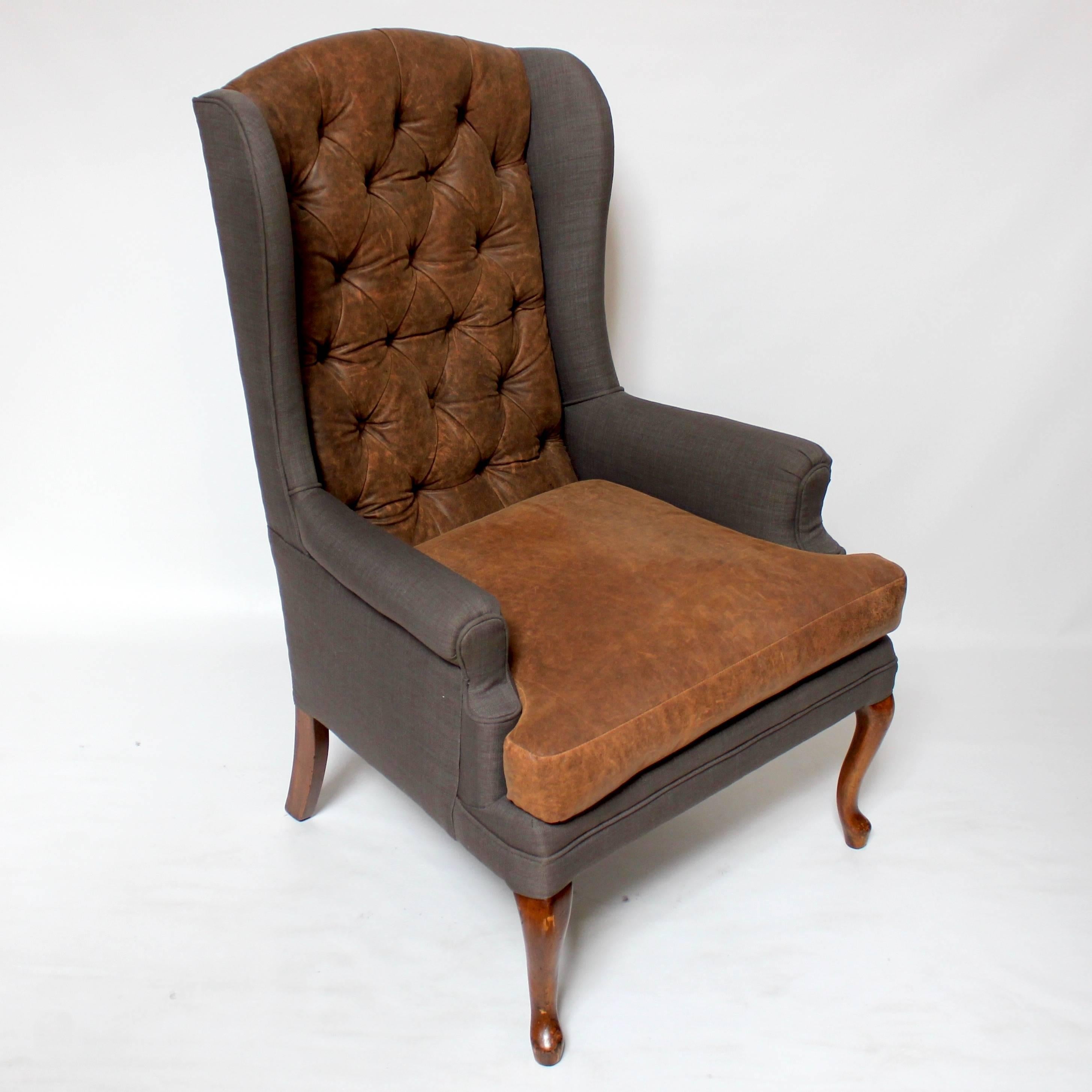 Pair of Mid-Century vintage wingback chairs, professionally reupholstered in custom Napa leather and grey fabric. The frames are American hardwood, and the tufted backs give the chairs the feel of a Classic Chesterfield, while the contrasting grey